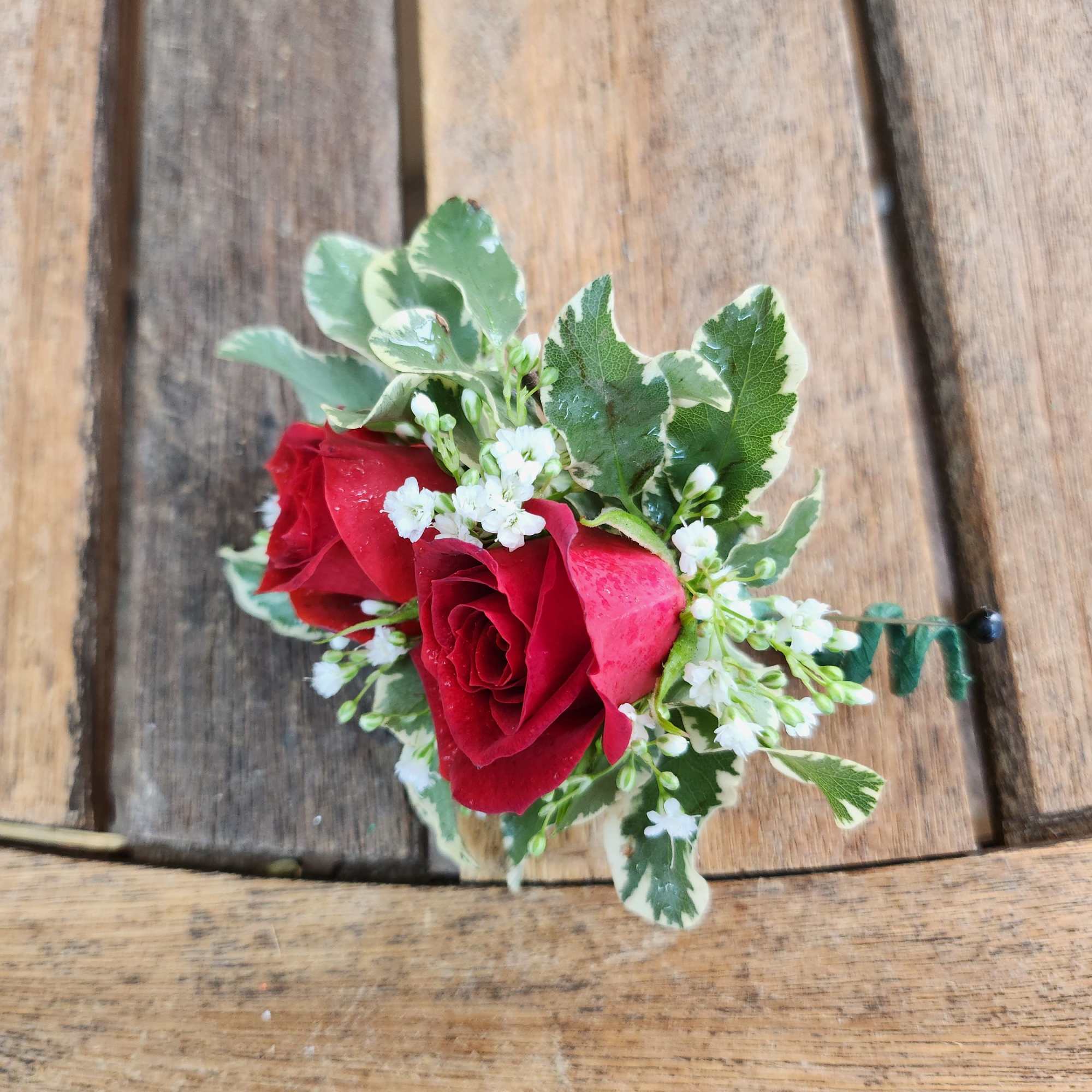 Small red rose boutonniere with white filler flowers and variegated leaves, photo 2 of 3
