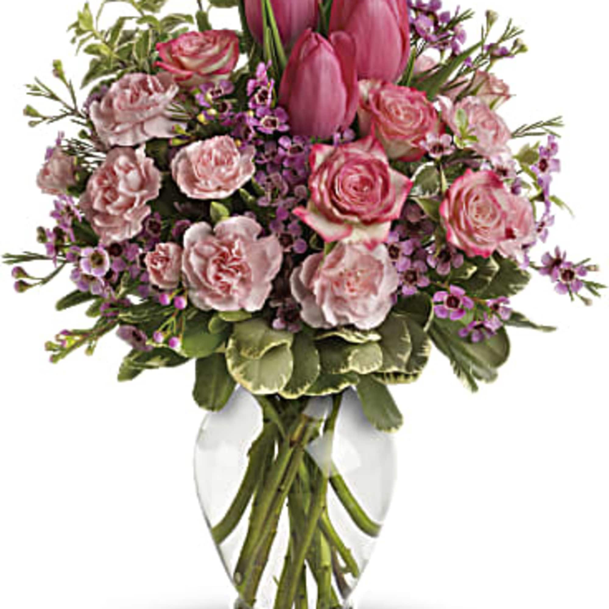 Pink tulips and roses arranged in a clear glass vase