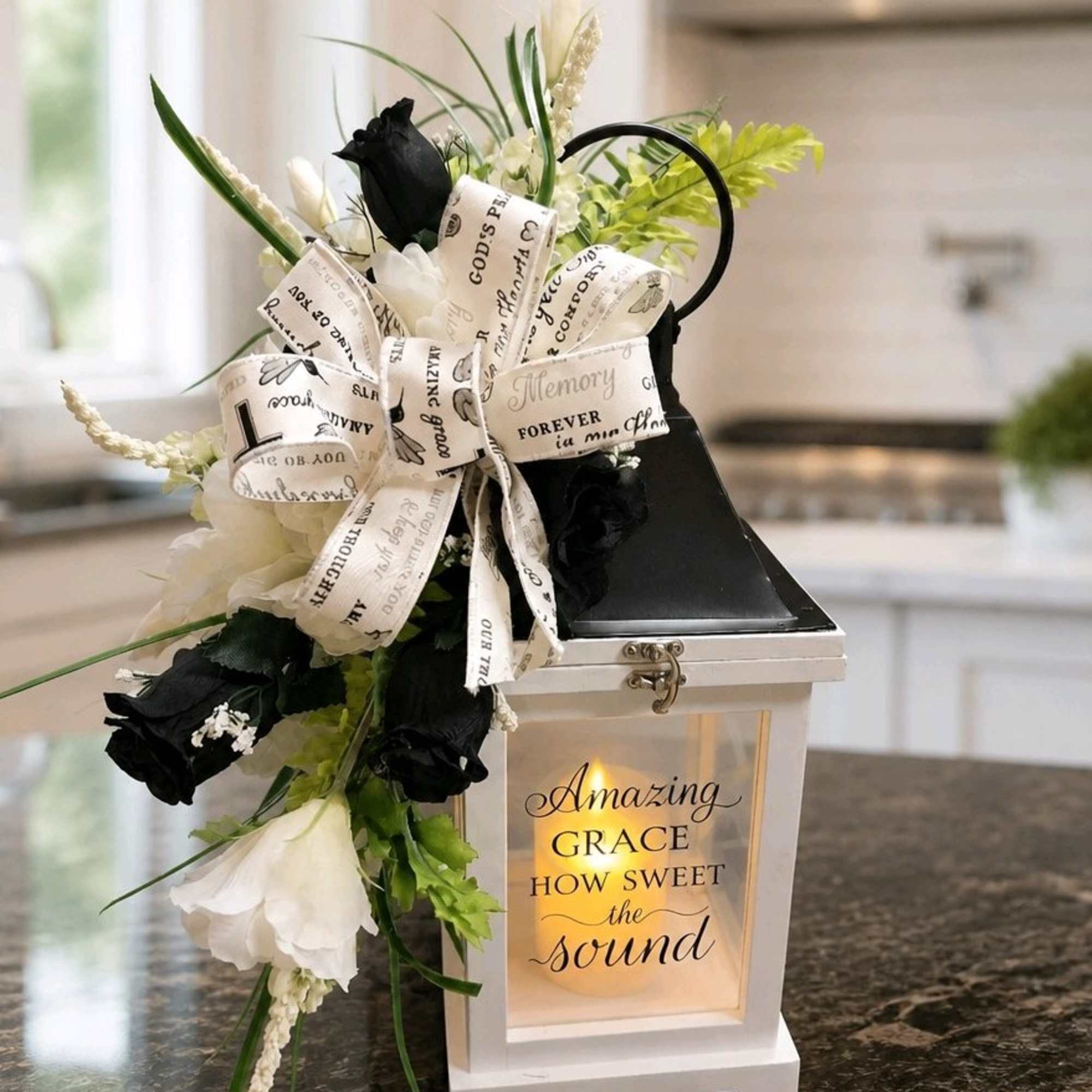 Black and white floral arrangement with a ribbon bow on a lantern
