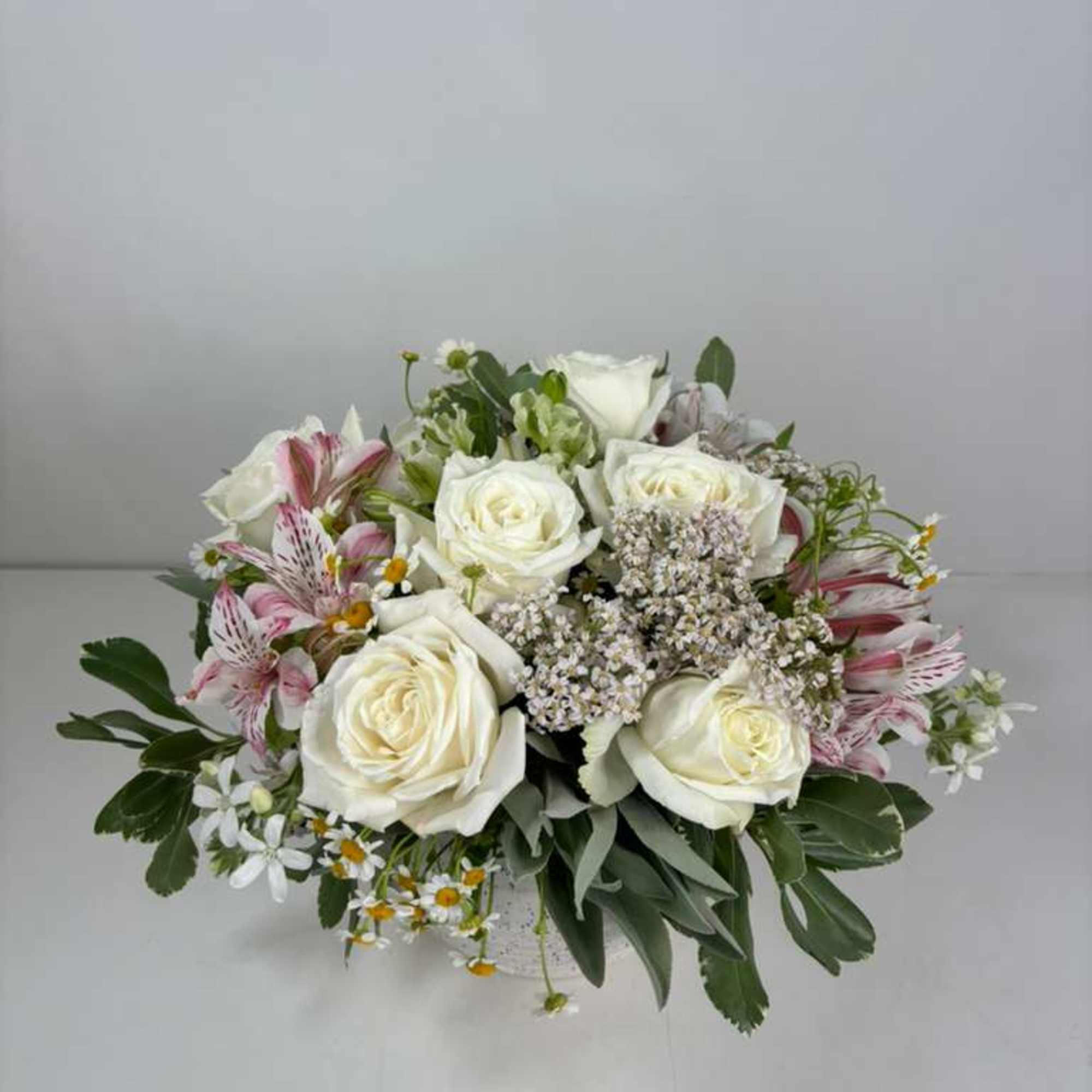 White roses and pink alstroemeria in a low bouquet