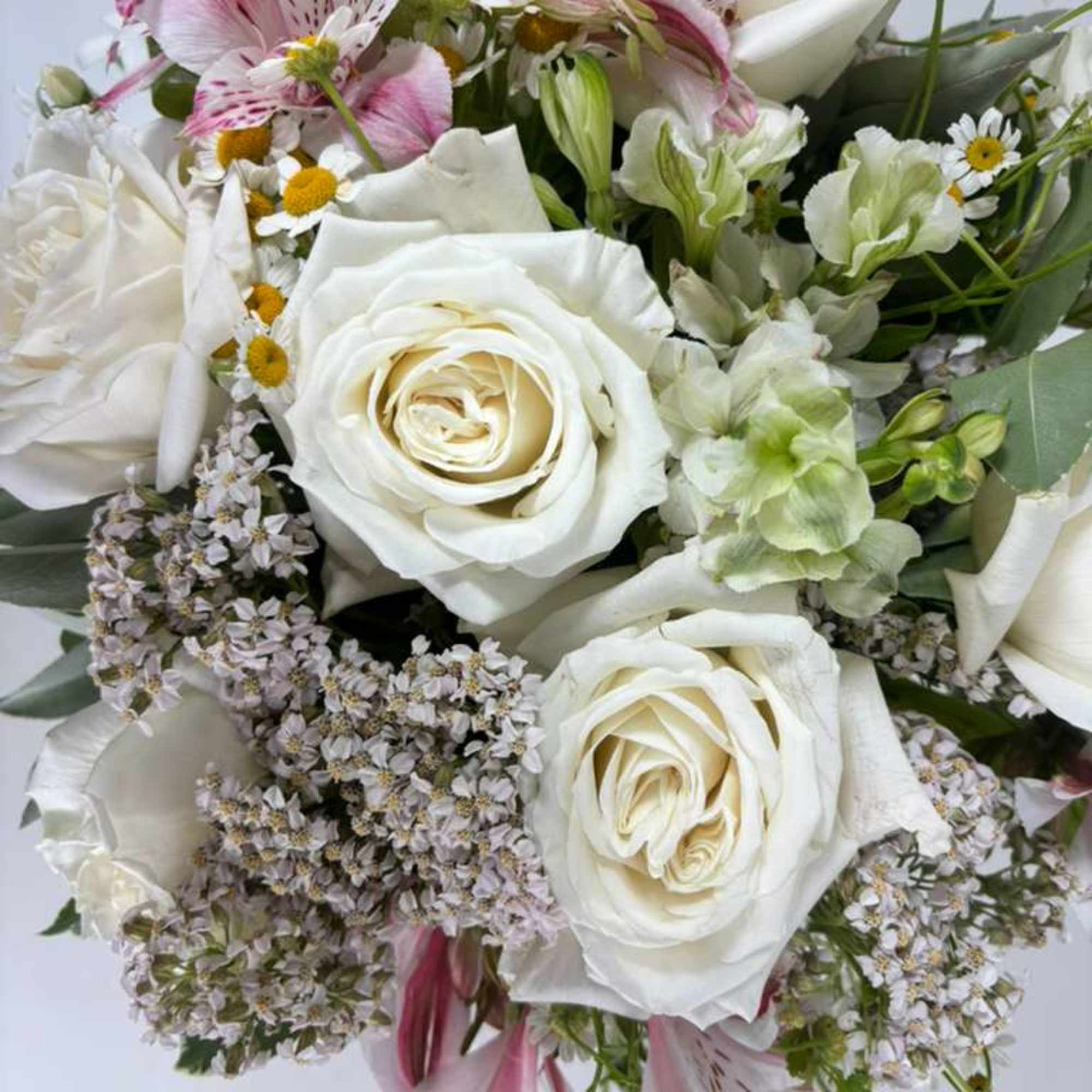Bouquet of white roses, pink alstroemeria, and small daisies