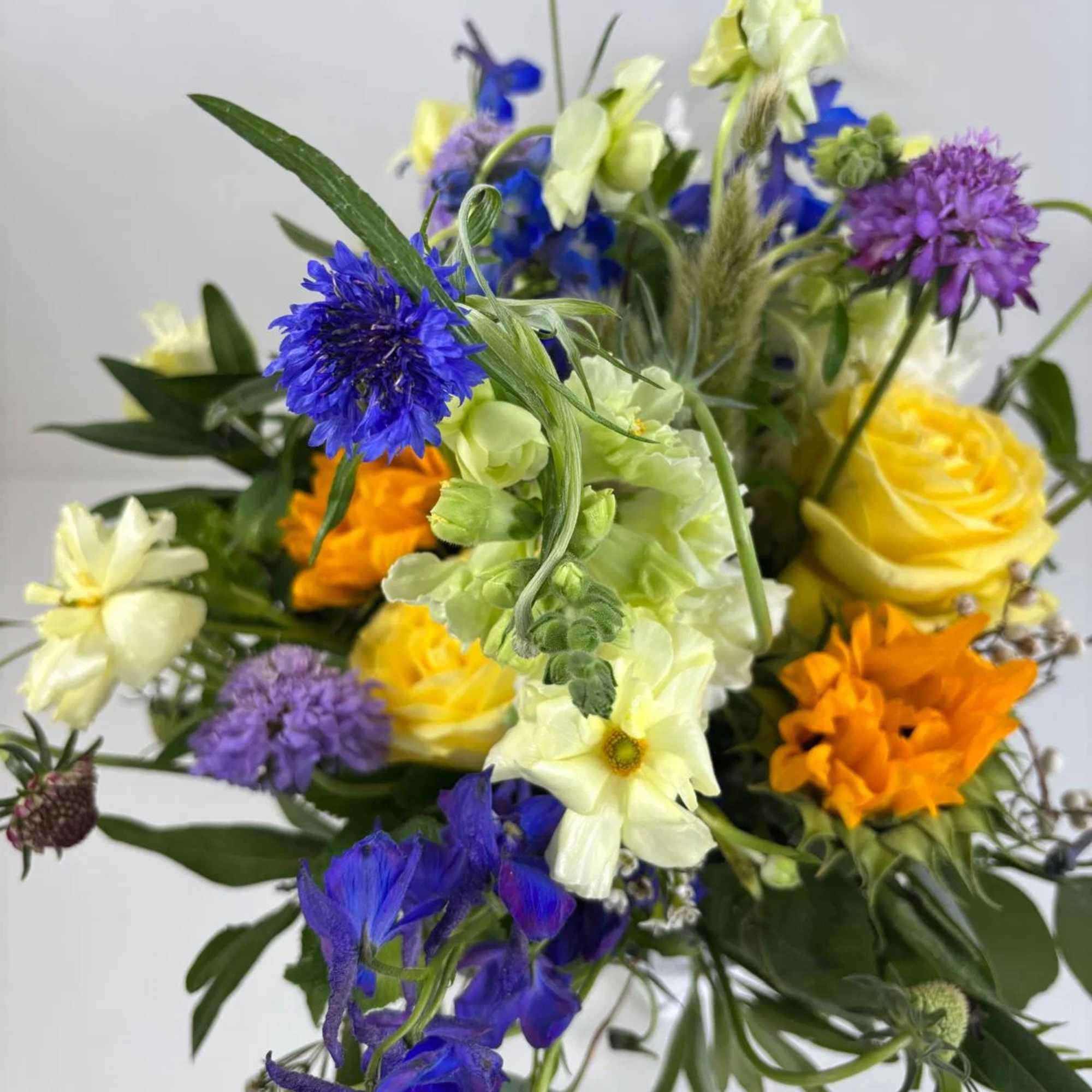 Mixed bouquet with blue, yellow, orange, and purple flowers, photo 5 of 6