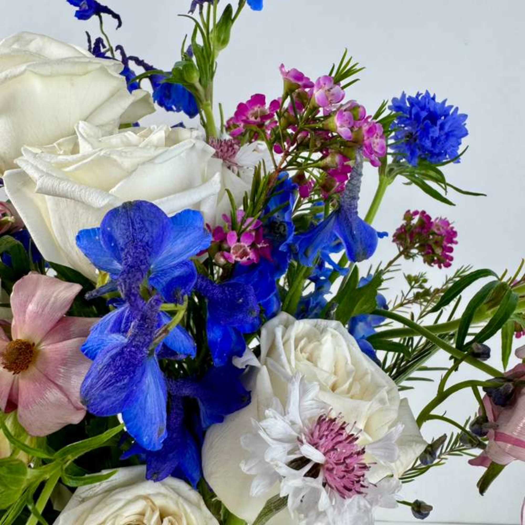 Bouquet of white roses with blue and pink mixed flowers