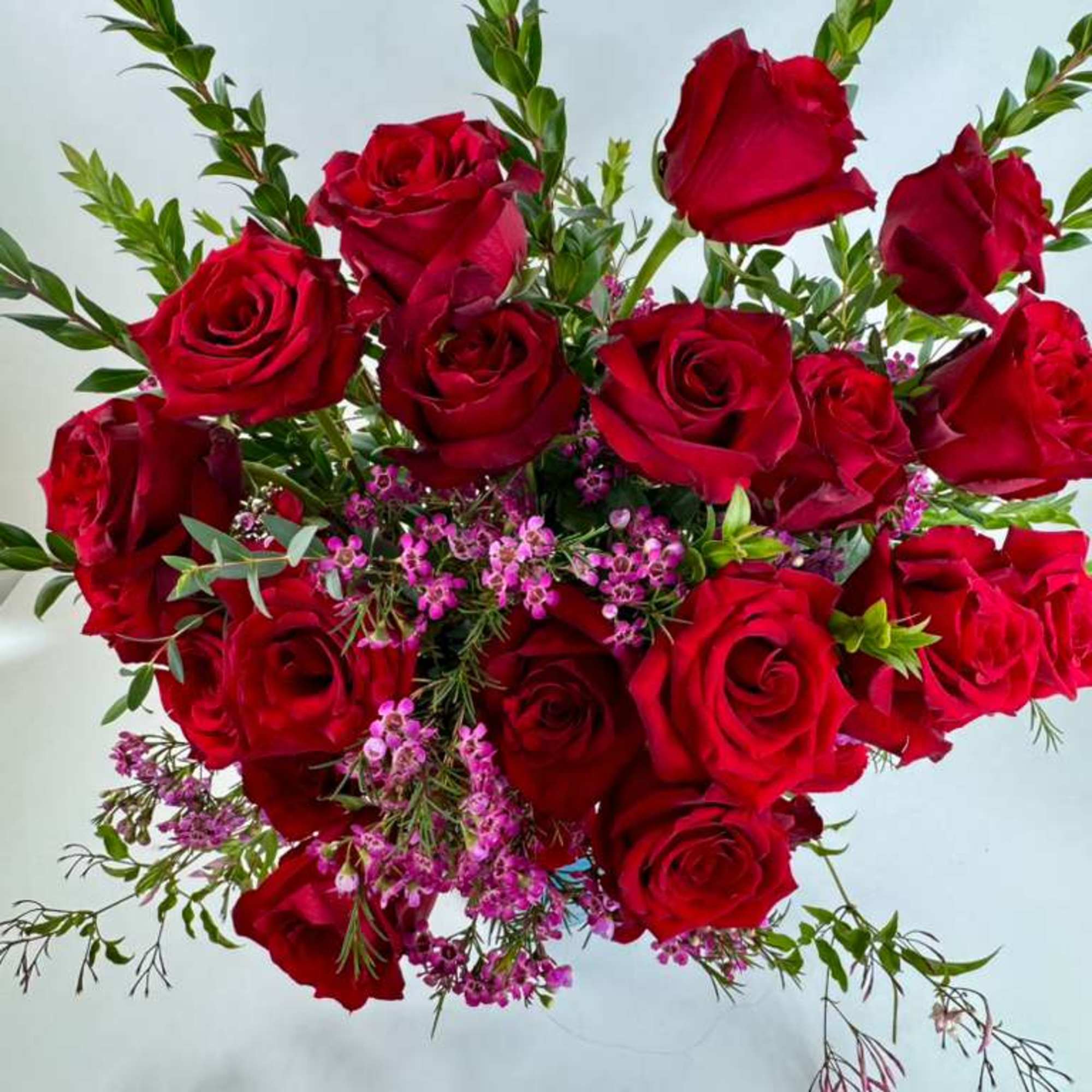 Bouquet of red roses with small purple filler flowers