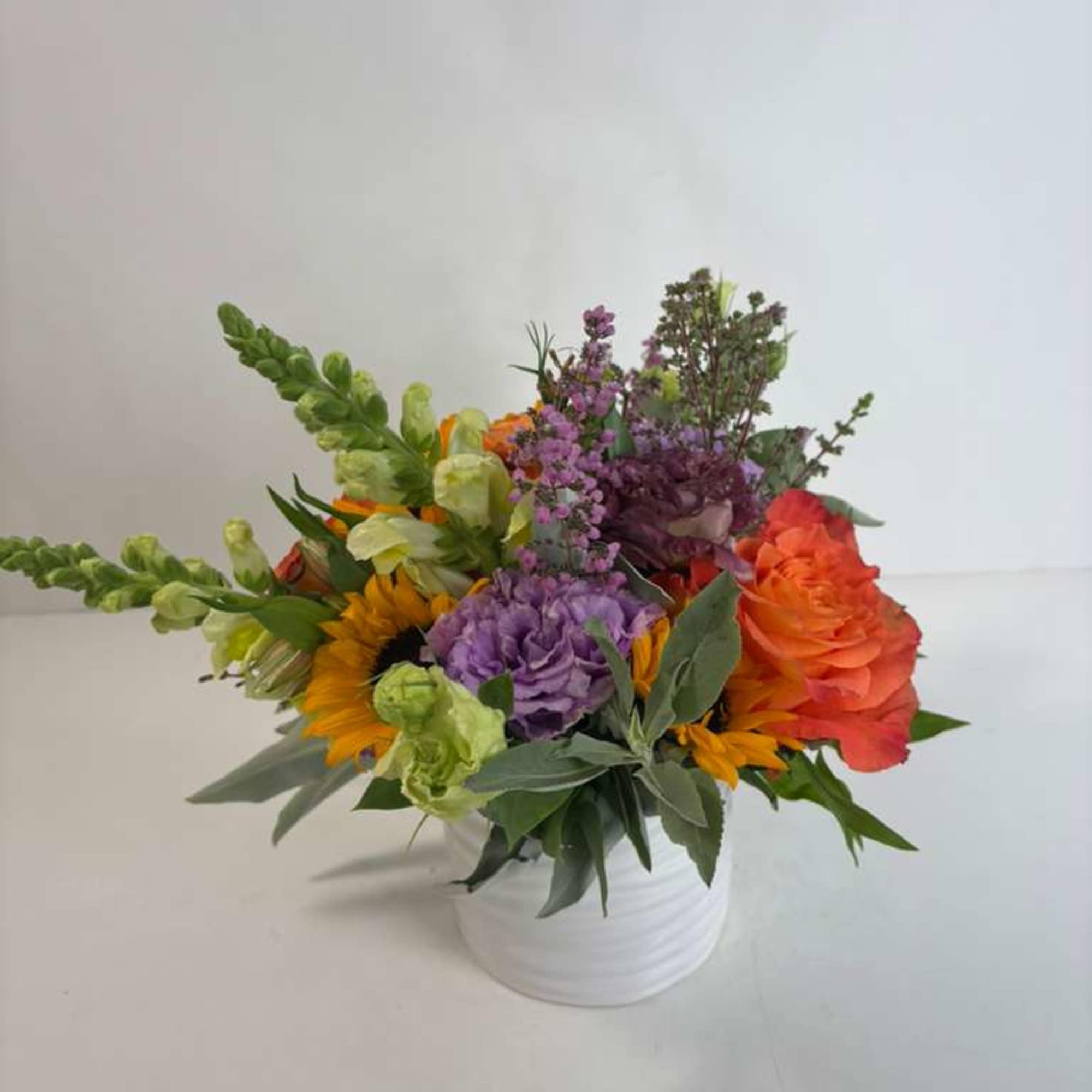 Colorful mixed flower arrangement in a white vase