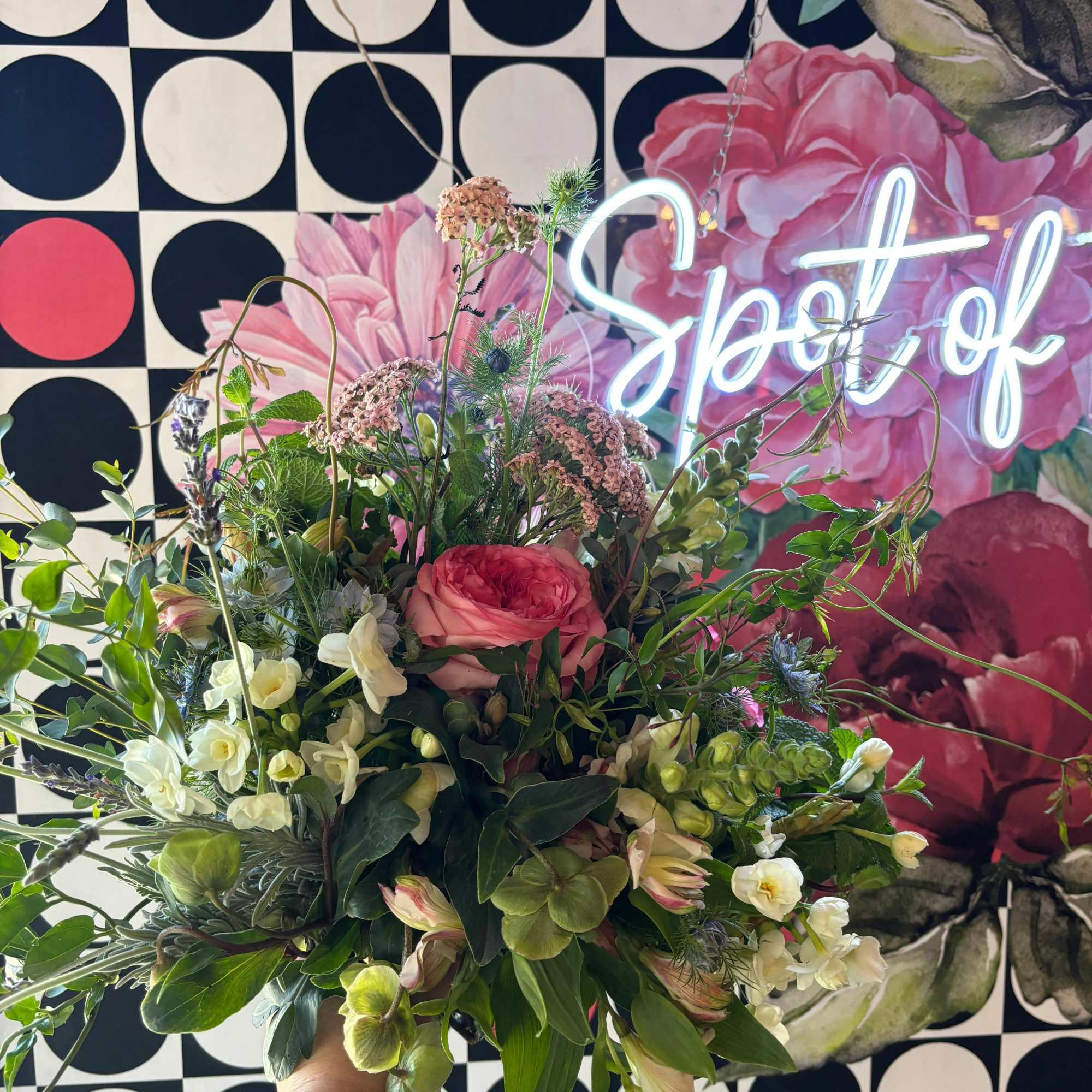 Handheld bouquet with pink and white flowers and mixed greenery