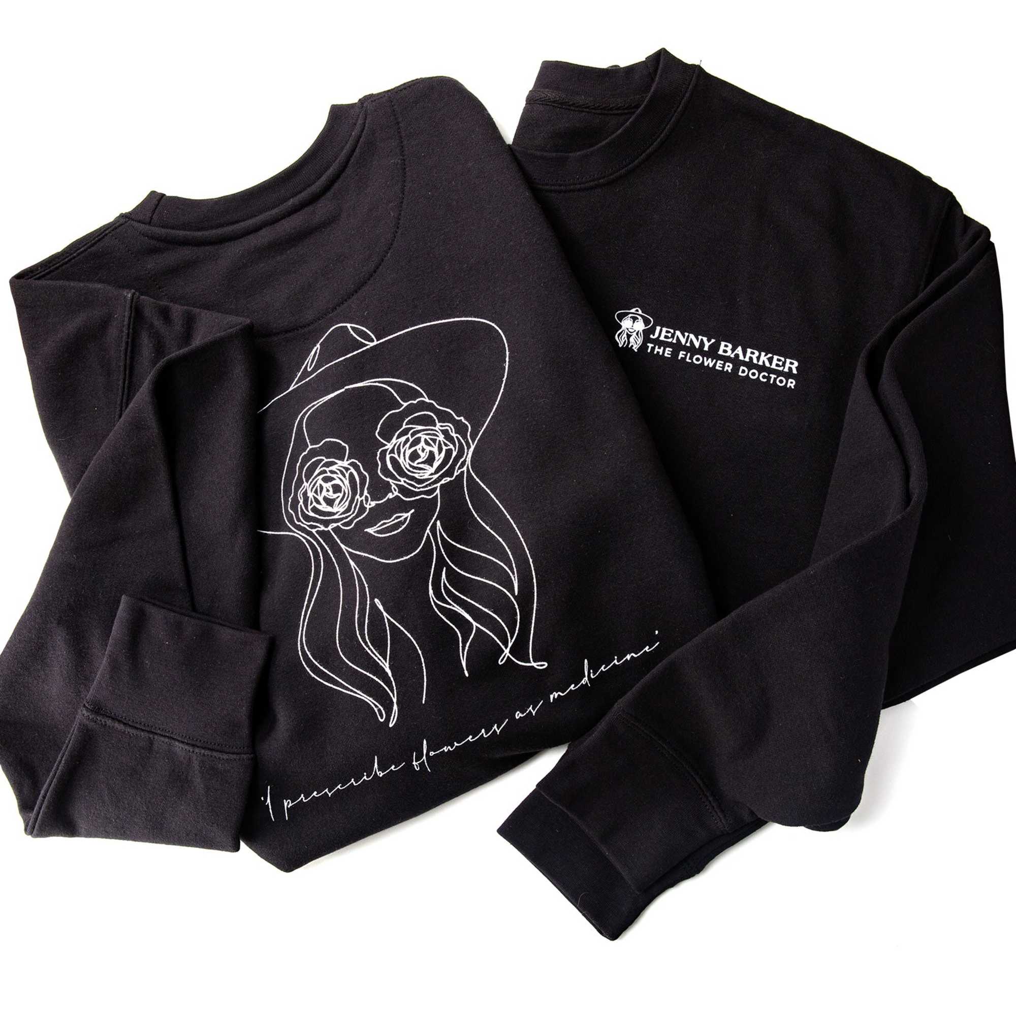 Two black sweatshirts with white floral line art and text