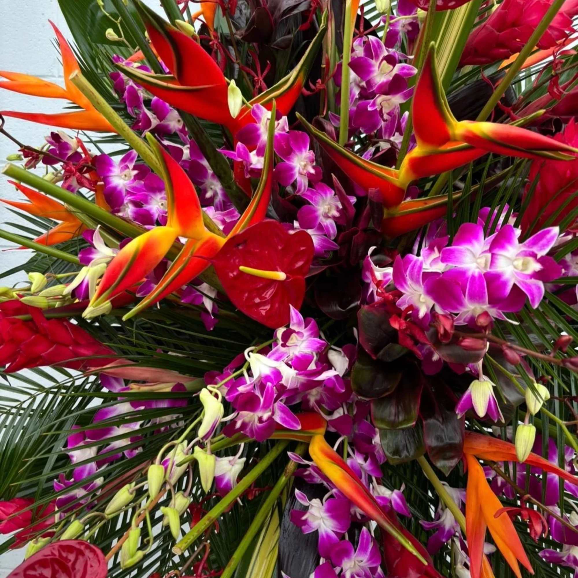Tropical bouquet with orange heliconia, purple orchids, and red anthuriums
