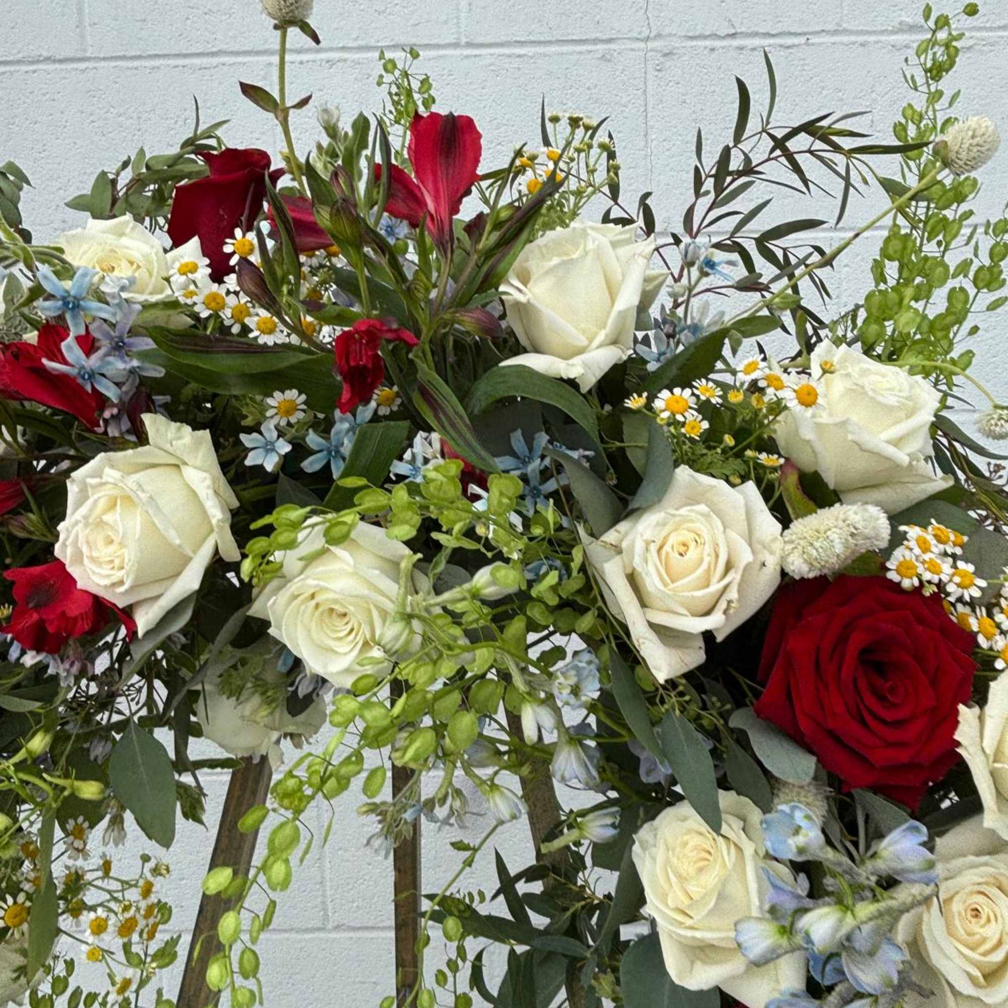 Mixed bouquet of red and white roses with small blue and yellow flowers