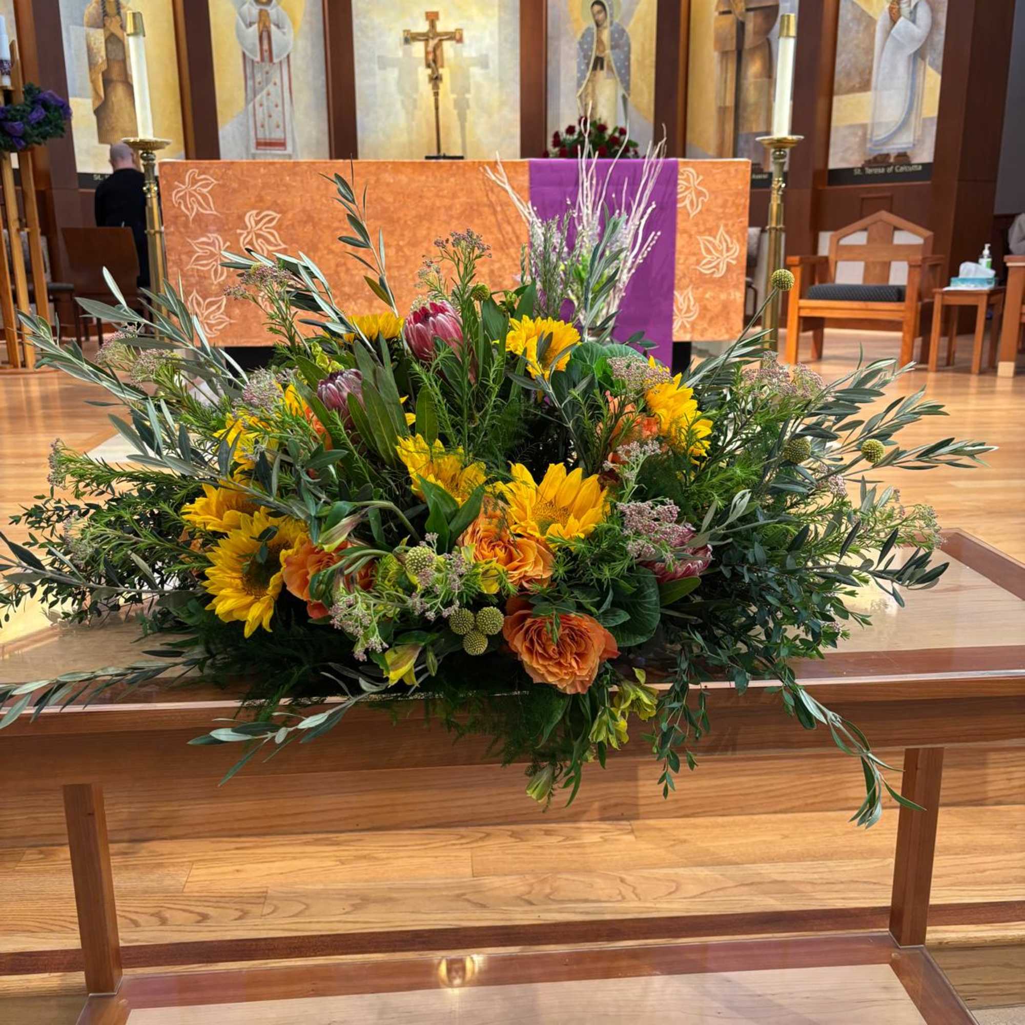 Large floral arrangement with sunflowers and orange blooms on a church altar, photo 2 of 2