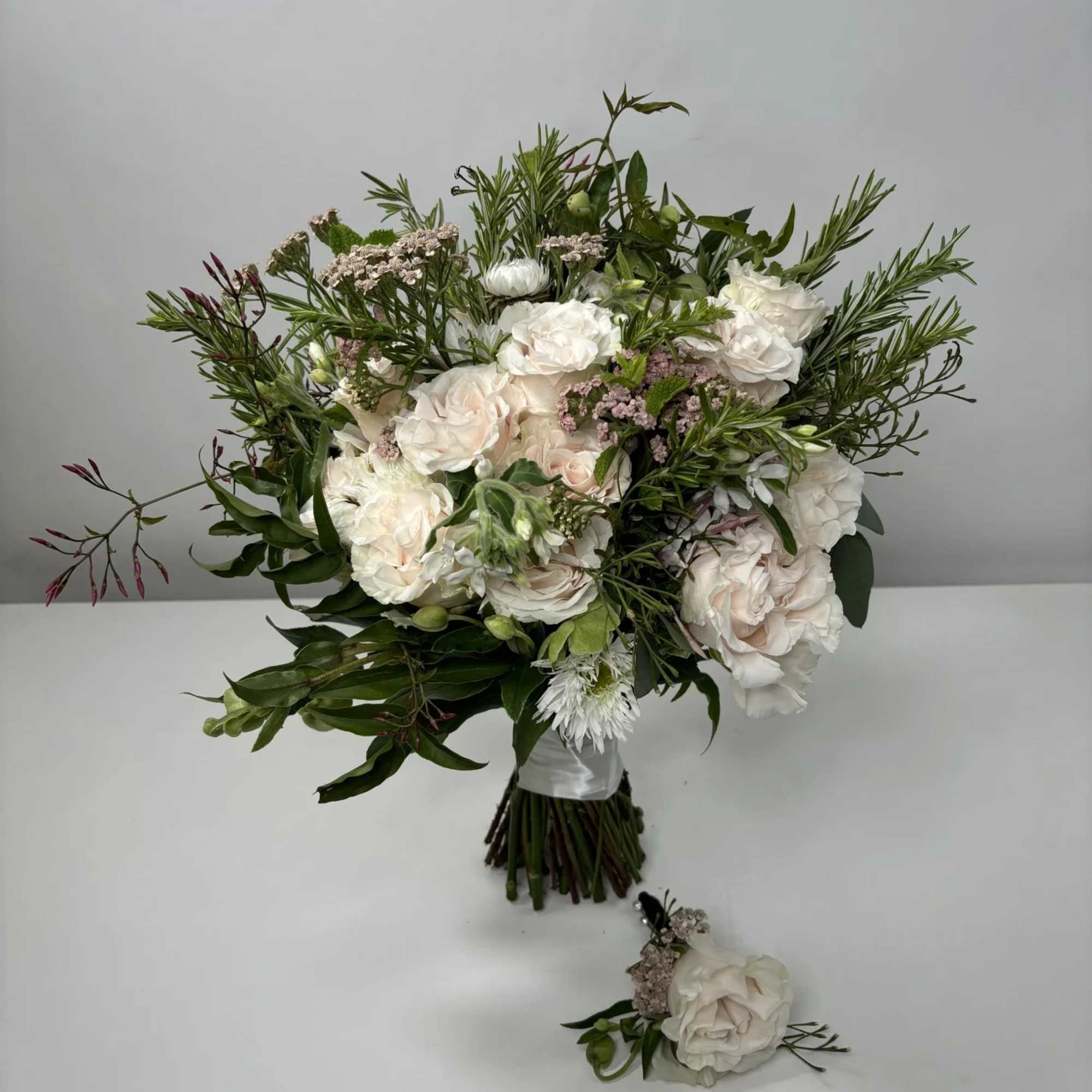 White and blush bouquet with greenery and a matching boutonniere