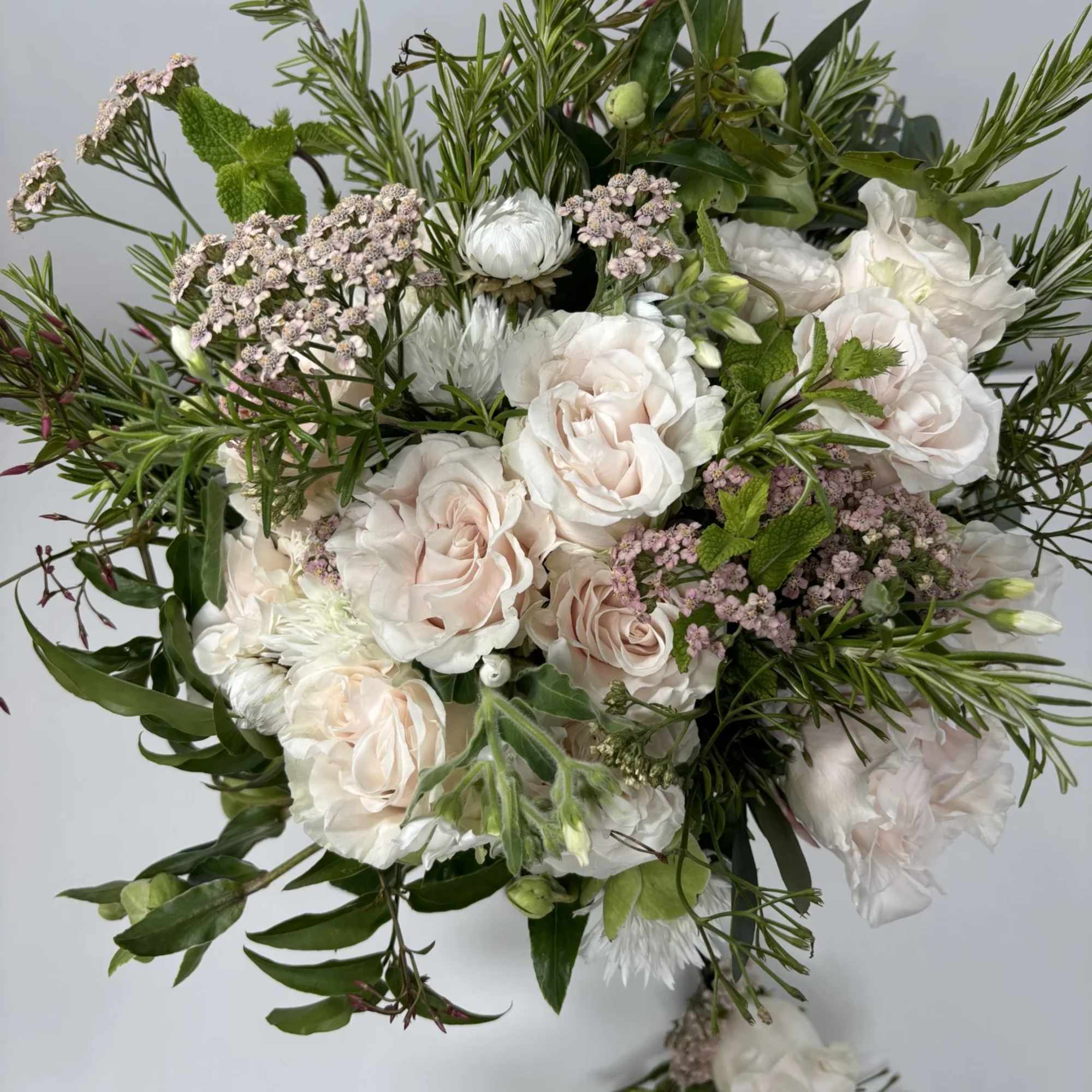 Bouquet of pale roses and white blooms with mixed greenery