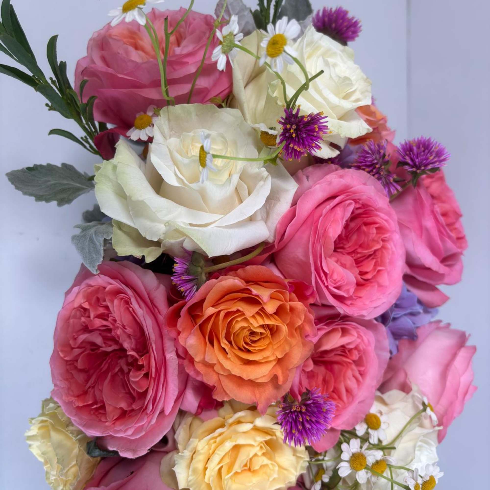 Bouquet of pink, white, and orange roses with small daisy-like flowers