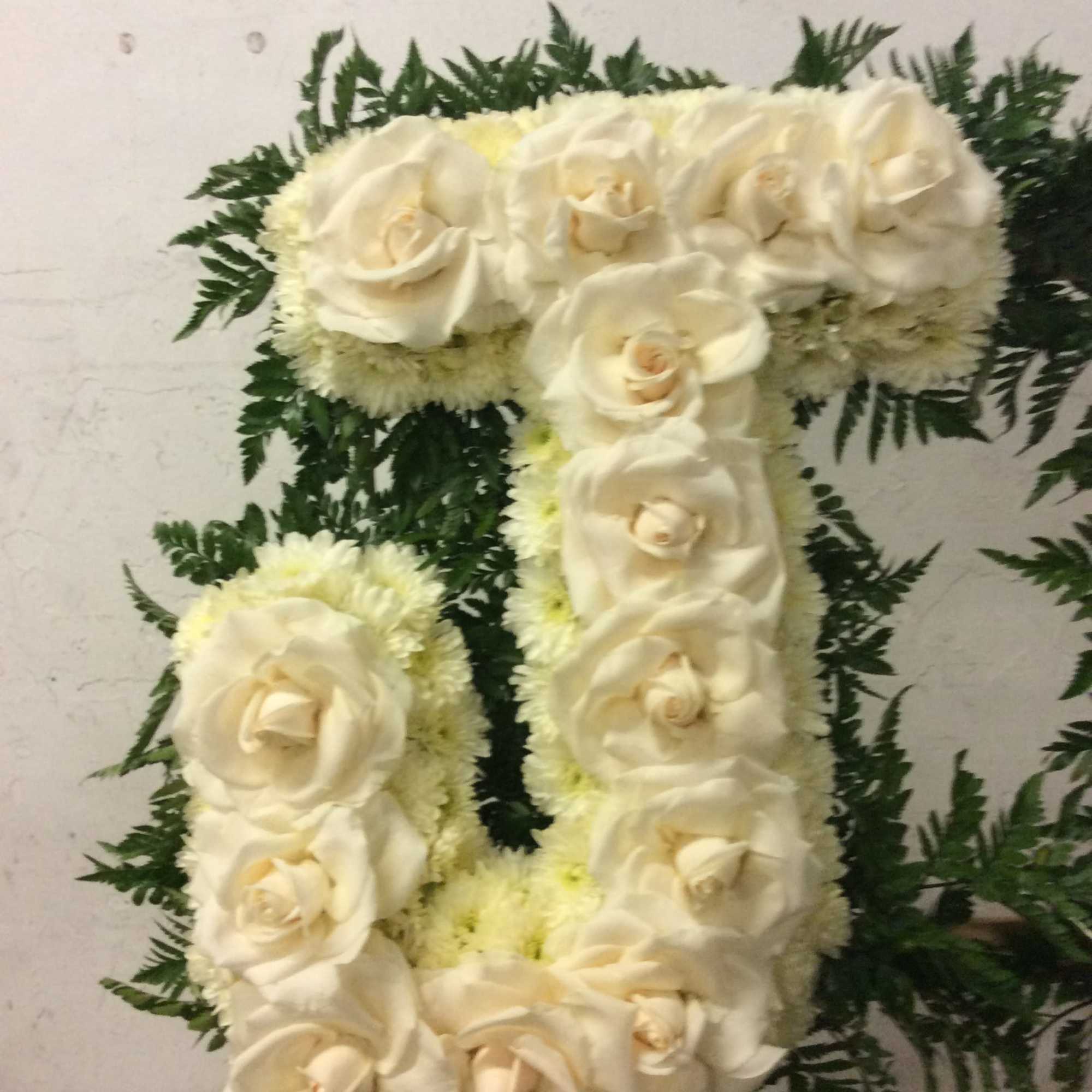 Floral arrangement shaped like the number 7 with white roses