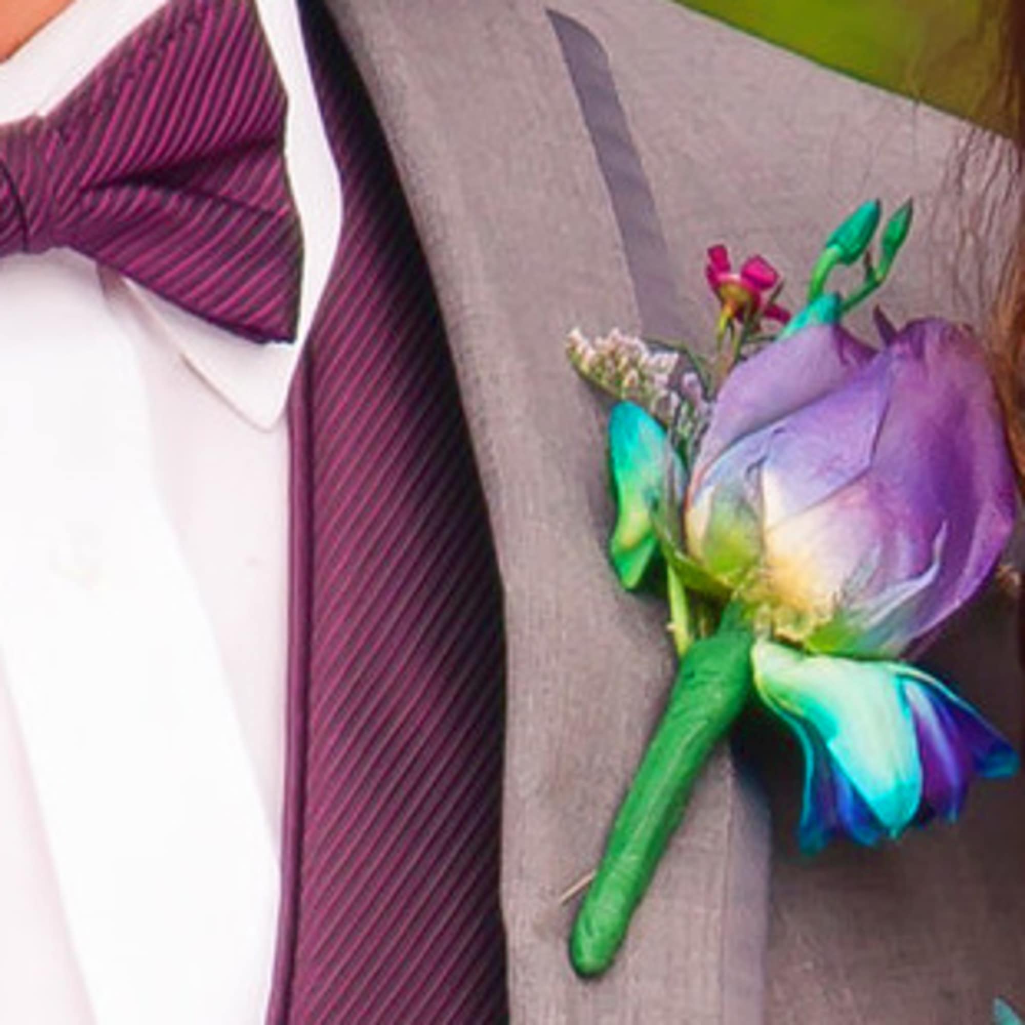 Rainbow-colored boutonniere pinned to a gray suit jacket