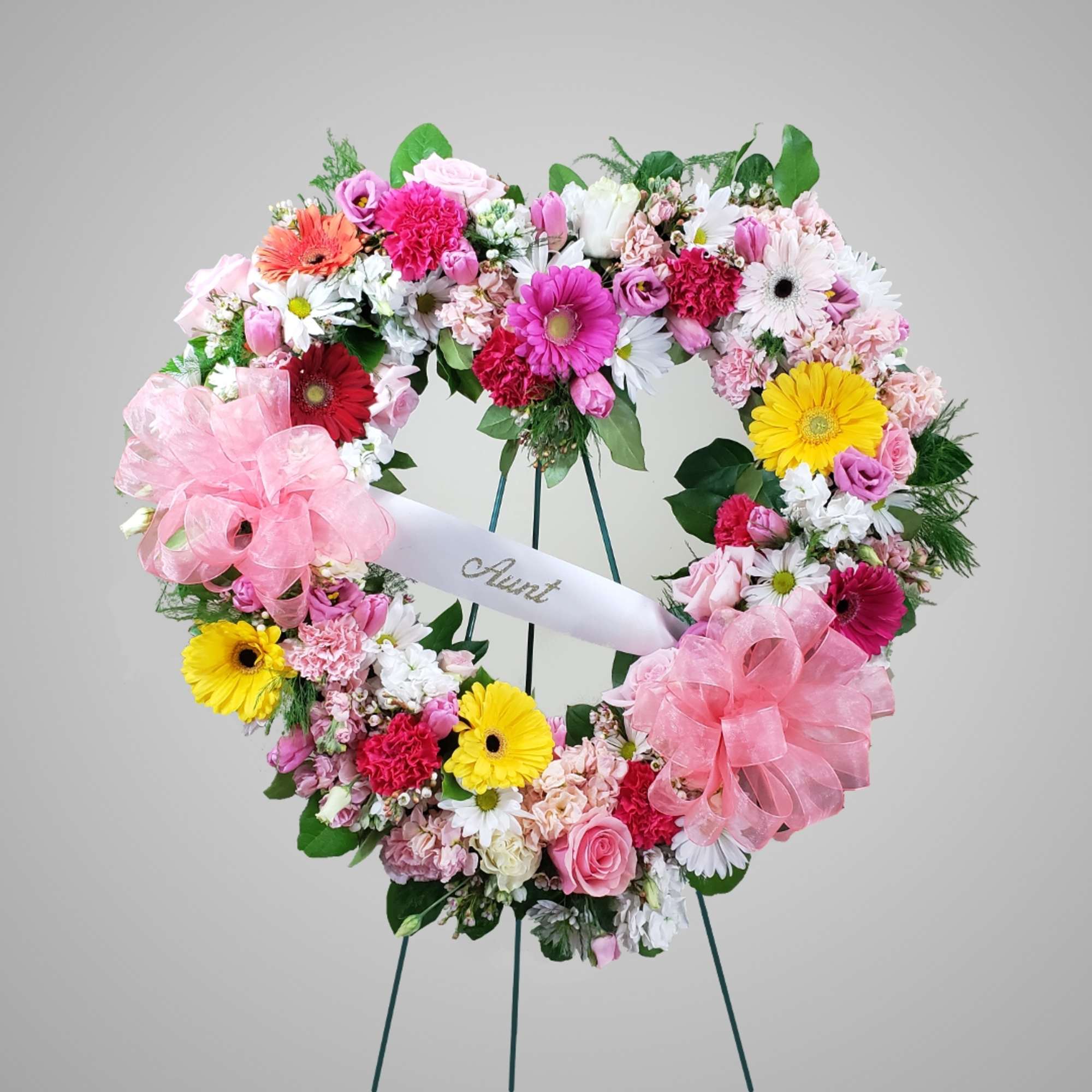 Heart-shaped floral wreath with pink, white, yellow, and red flowers