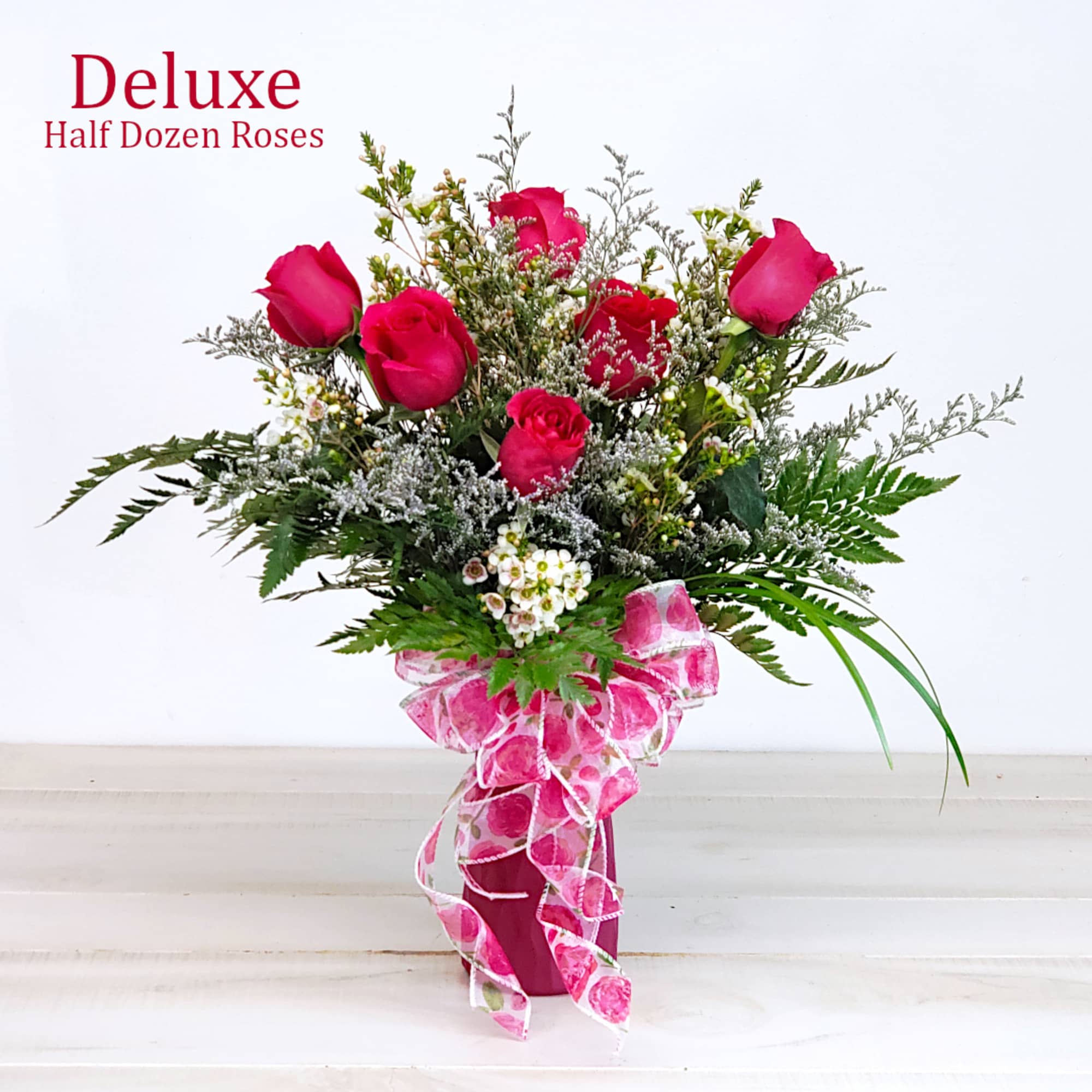 Pink rose bouquet in a vase with a decorative ribbon
