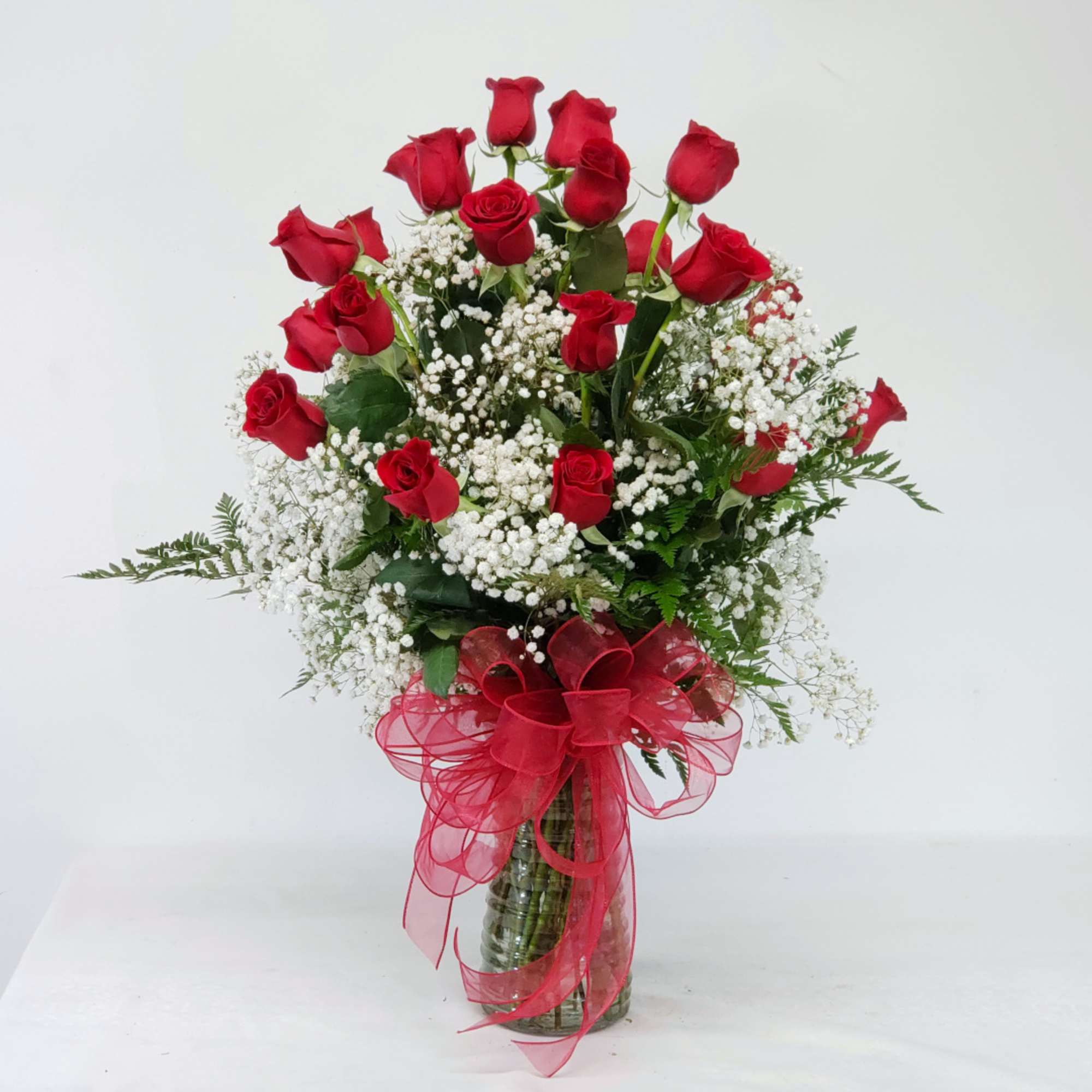 Bouquet of red roses with white baby's breath in a glass vase