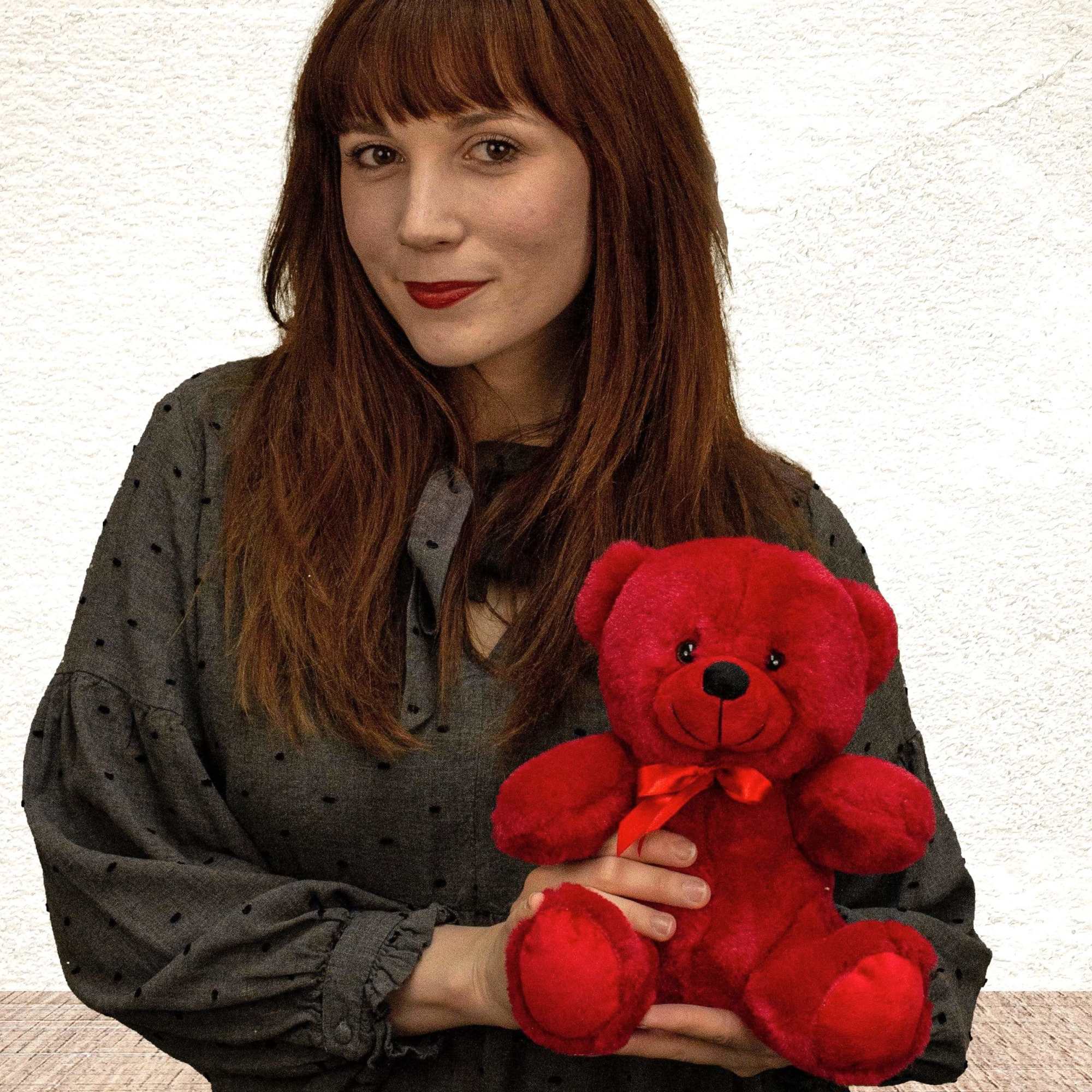 Woman holding a red teddy bear with a ribbon
