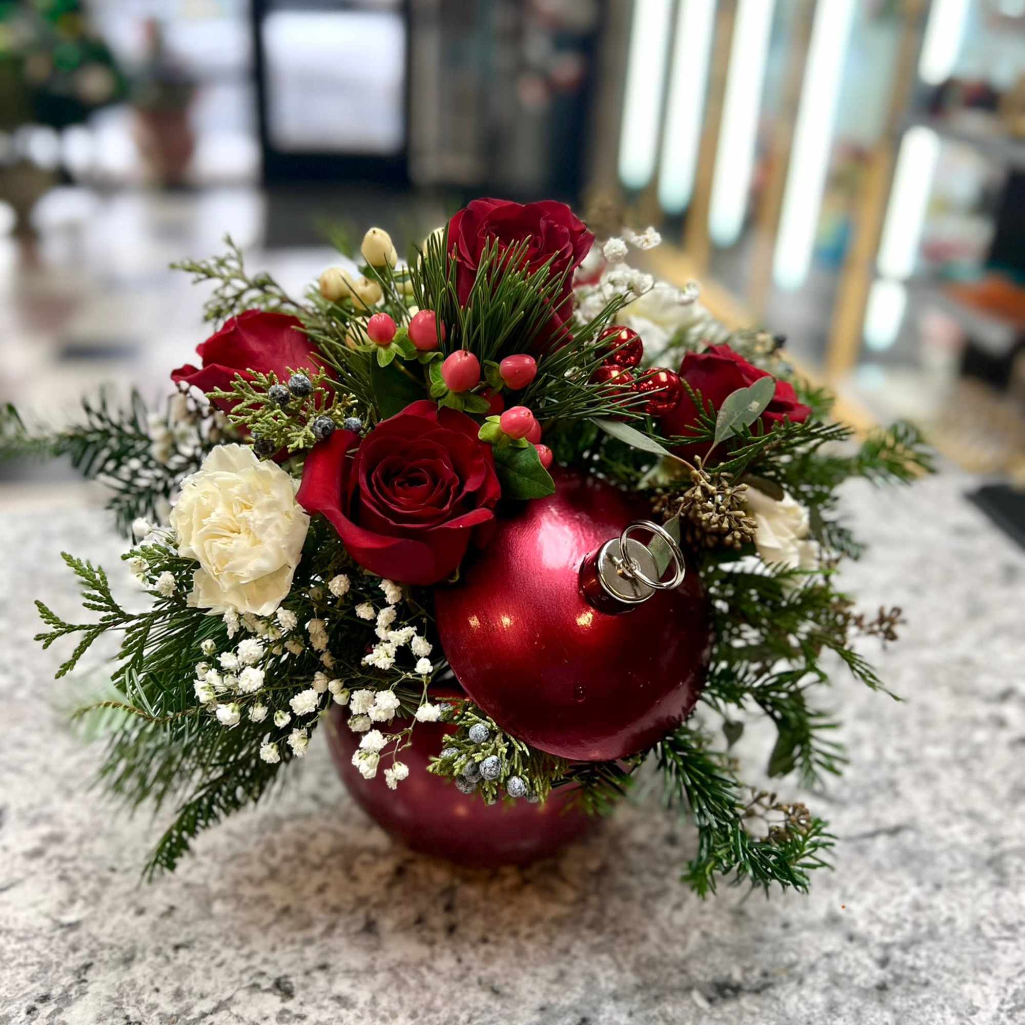 An elegant combination of red flowers, nestled in a bed of Christmas