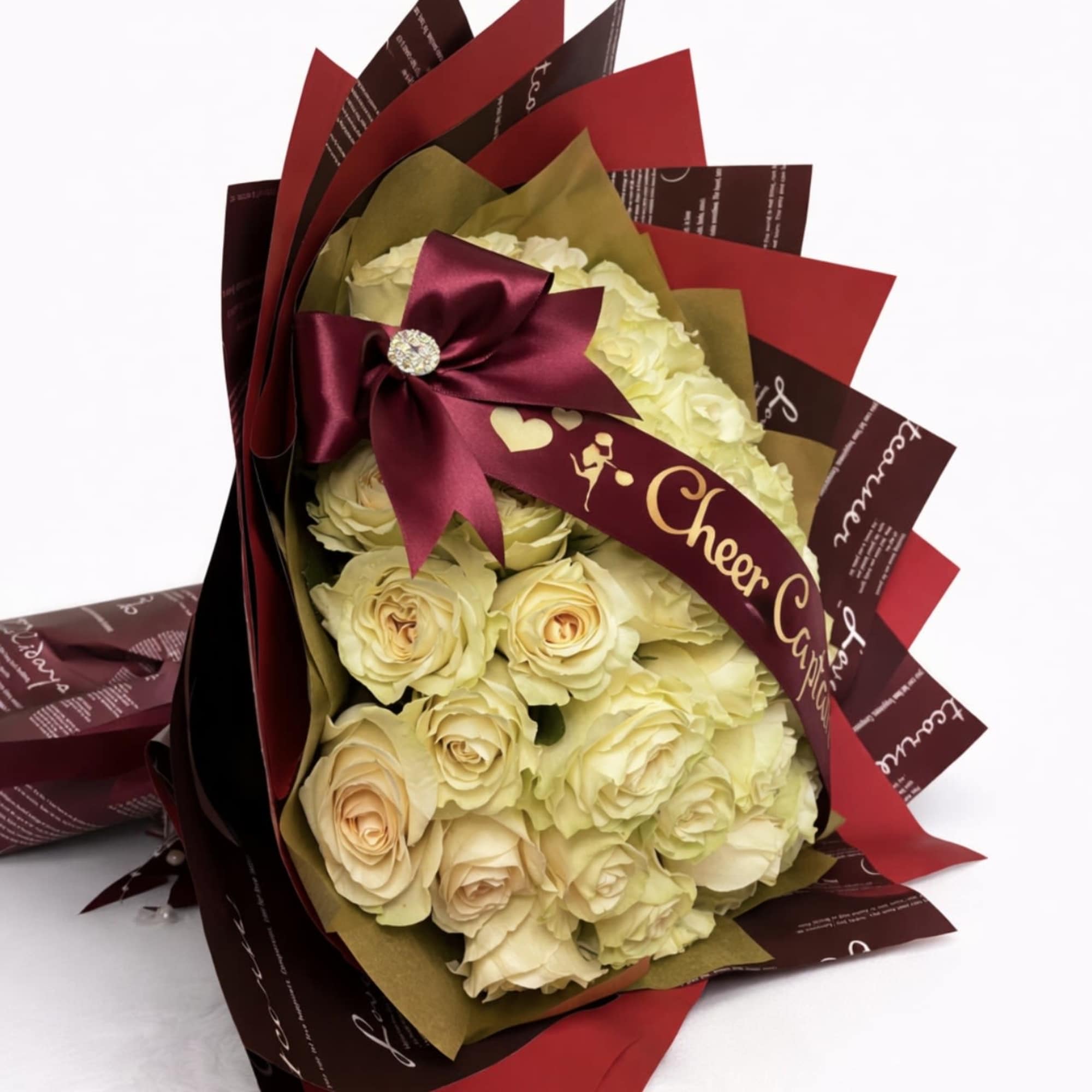 Bouquet of cream roses wrapped in burgundy and red paper with a satin bow