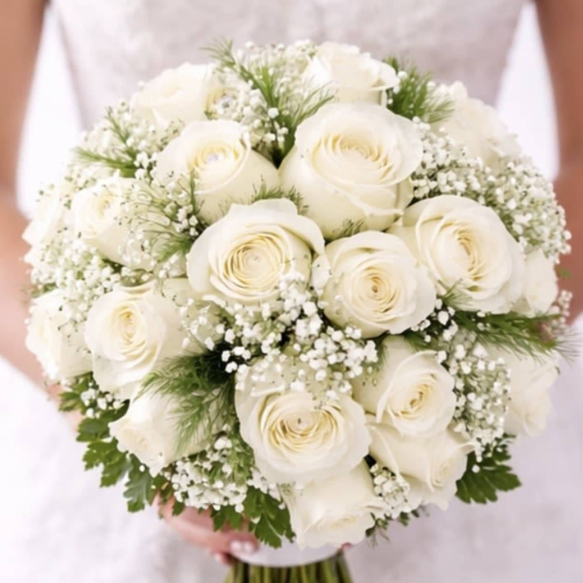 Bride holding a bouquet of white roses with baby's breath