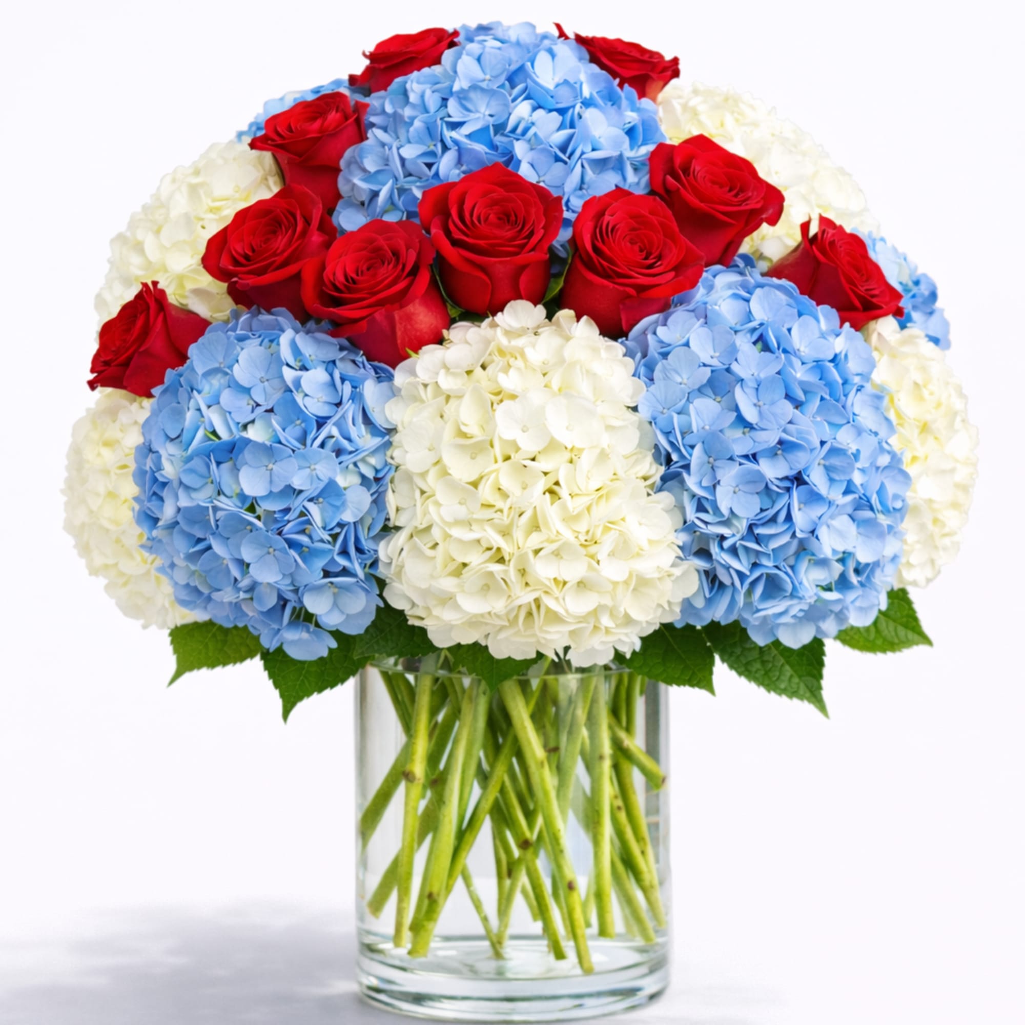 Bouquet of red roses and blue and white hydrangeas in a glass vase