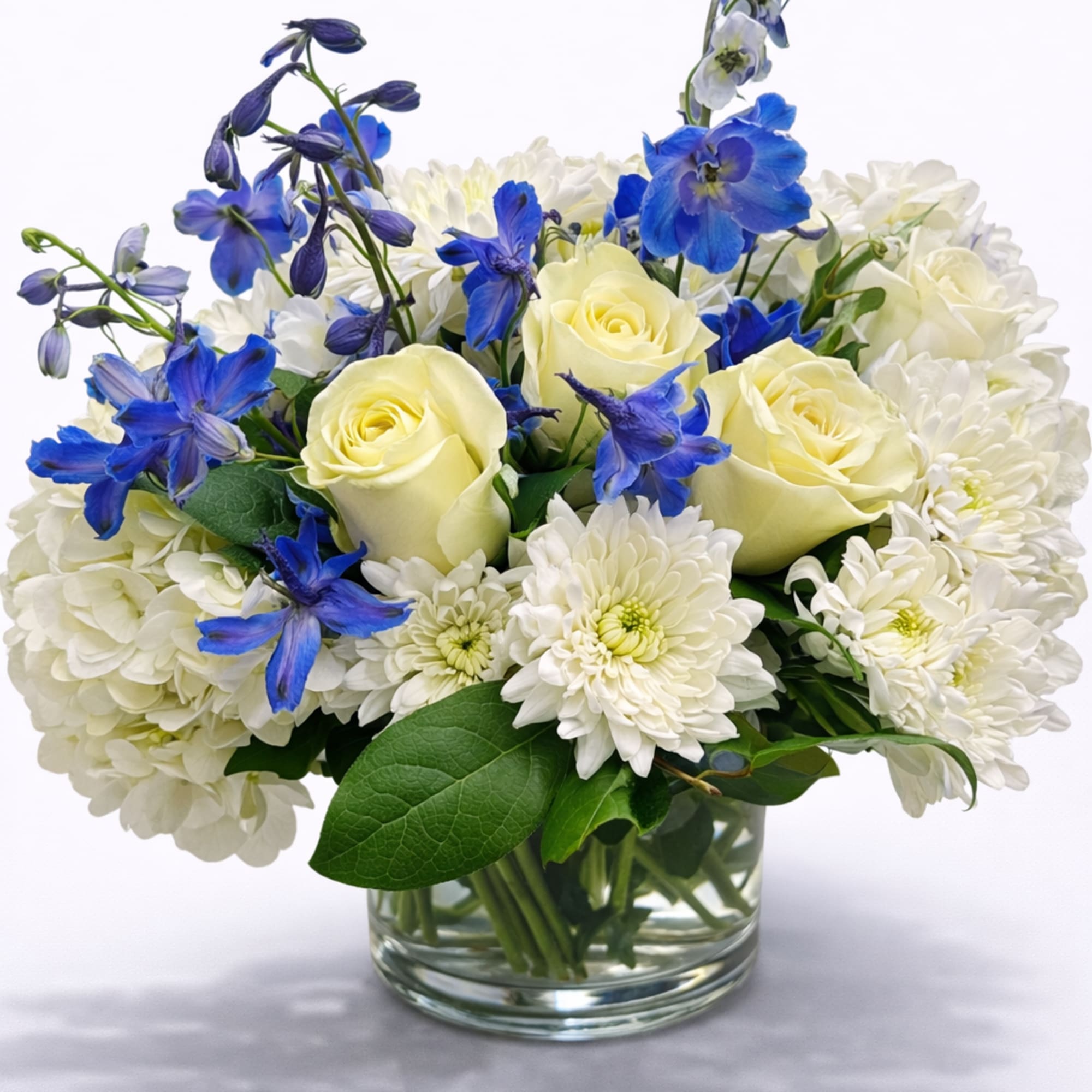 White and blue flower arrangement in a clear glass vase
