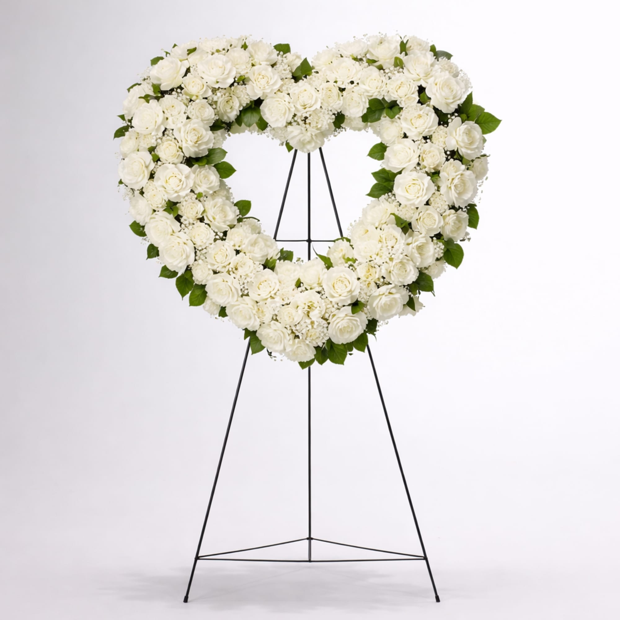 Heart-shaped white rose funeral wreath on a black stand