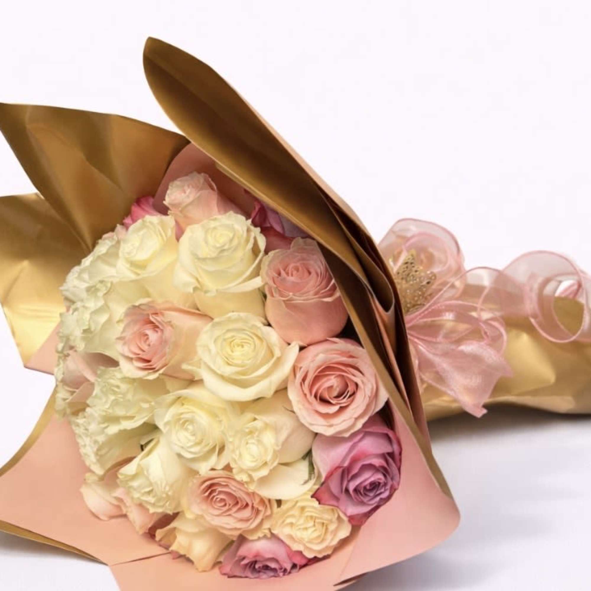 Bouquet of pink and cream roses wrapped in gold and pink paper