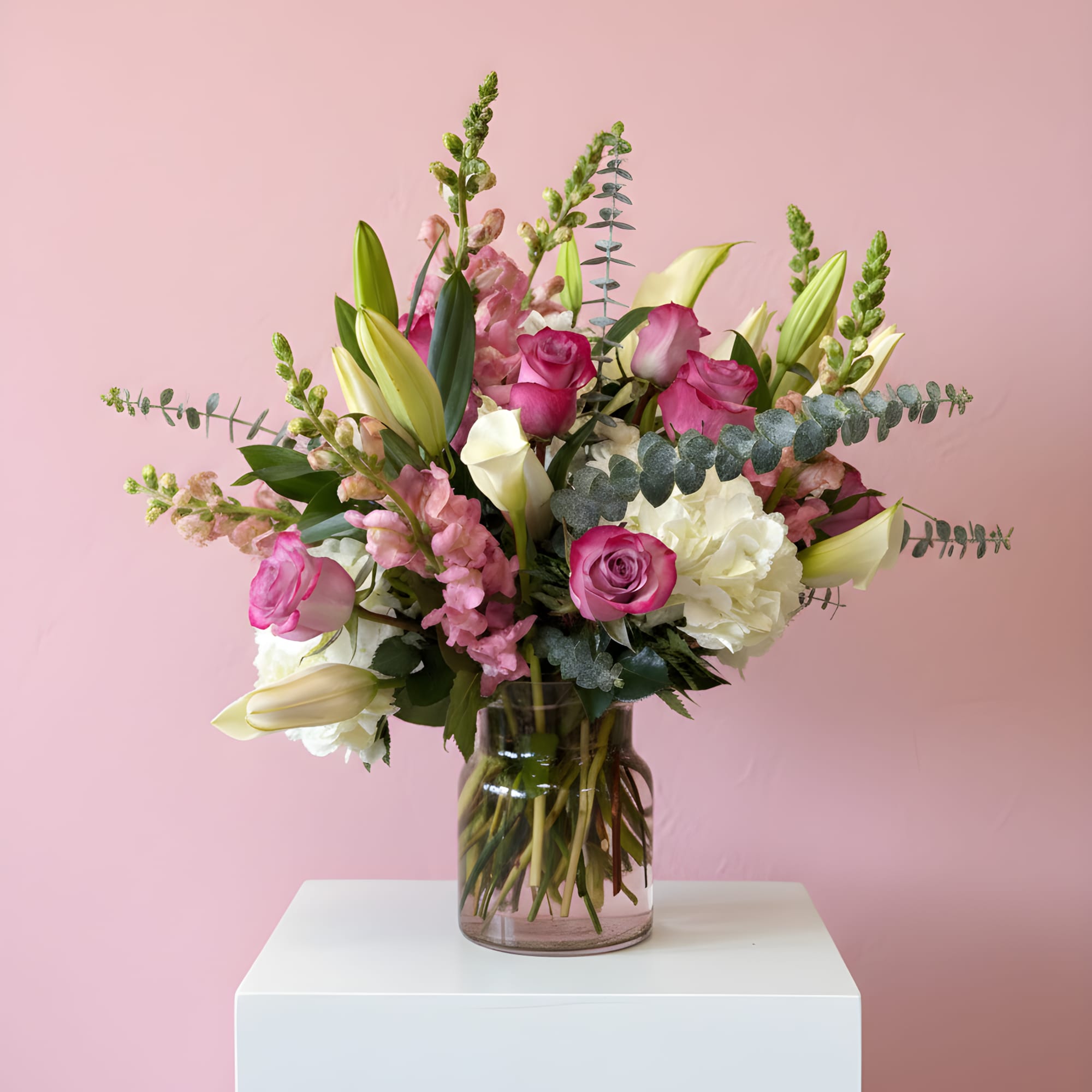 Pink and white floral arrangement in a glass vase