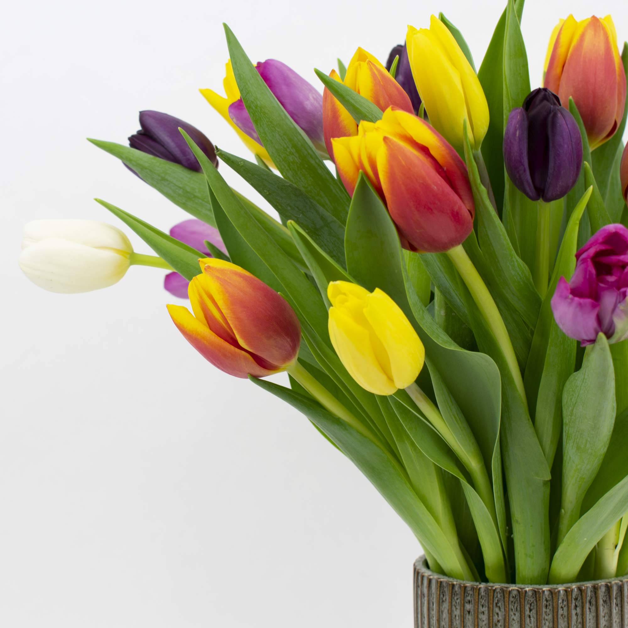 Bouquet of multicolored tulips in a ribbed vase, photo 2 of 4