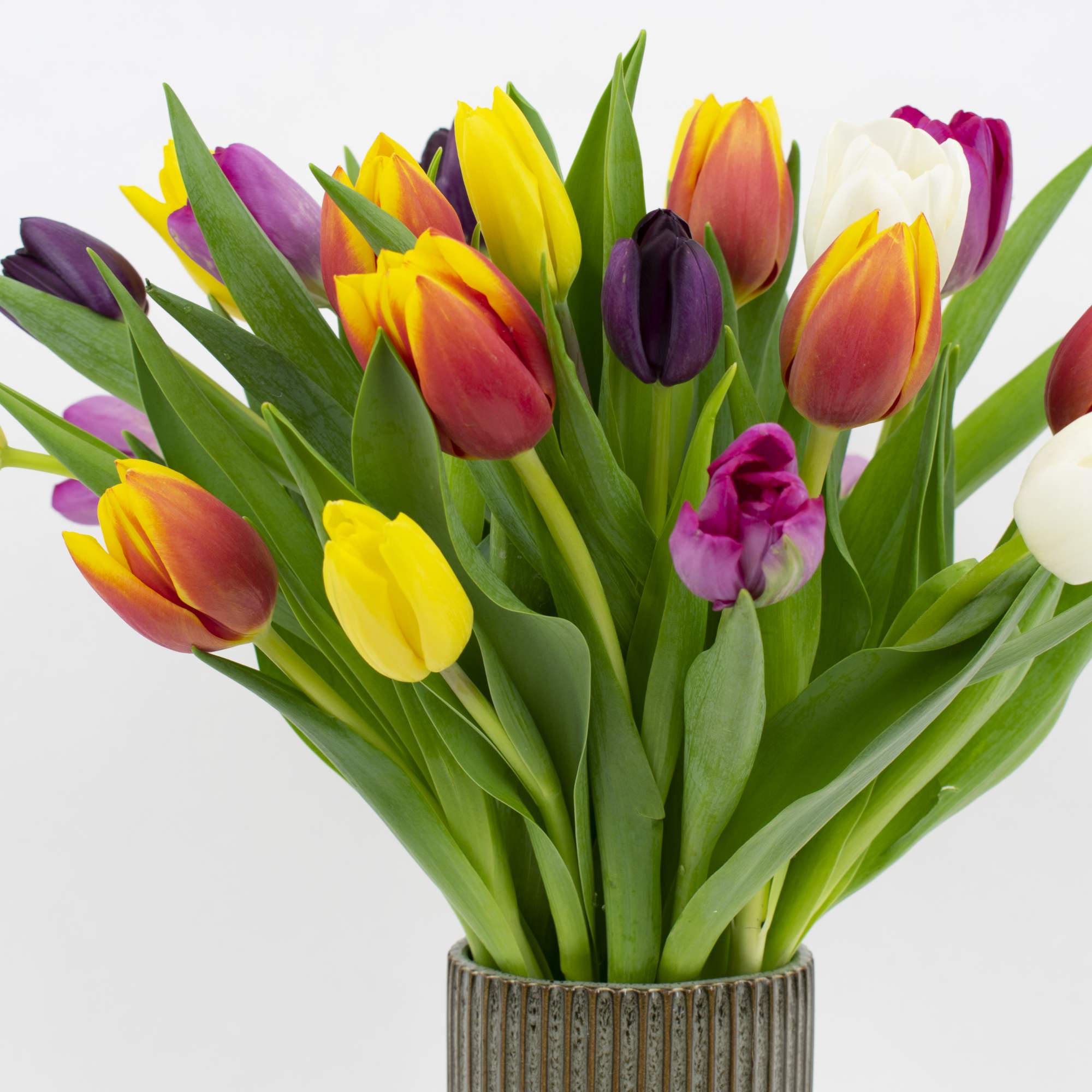 Bouquet of multicolored tulips in a ribbed vase, photo 3 of 4