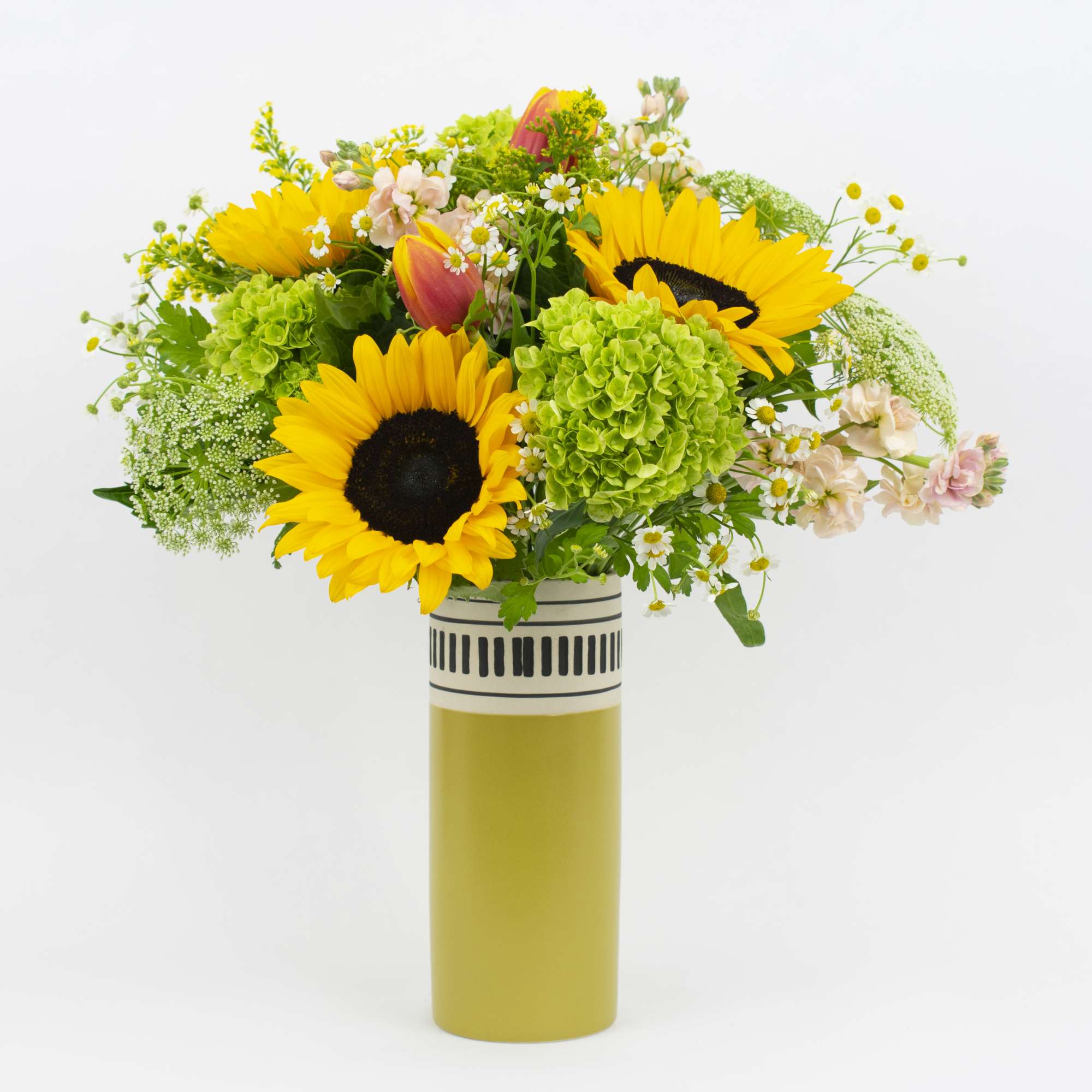 Bouquet of sunflowers and mixed blooms in a tall vase