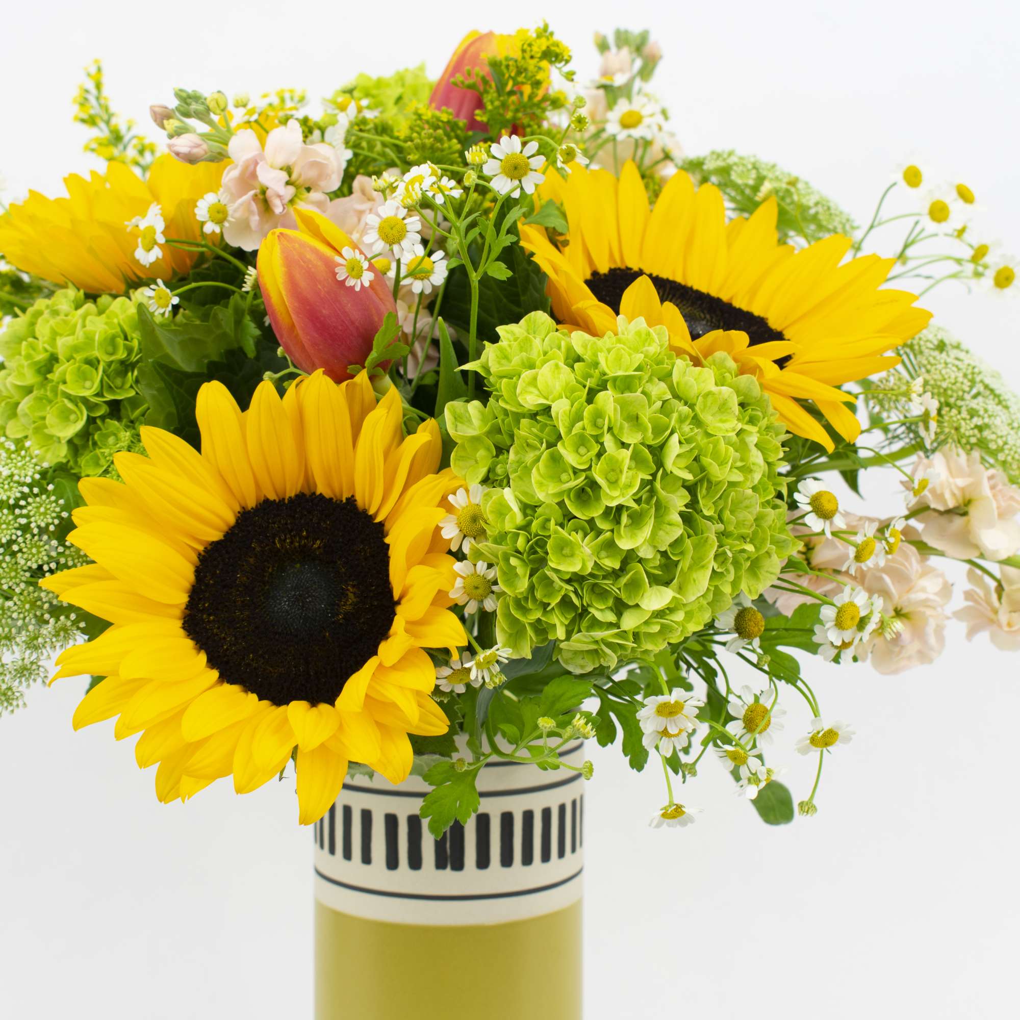Bouquet of sunflowers, hydrangeas, and mixed blooms in a striped vase