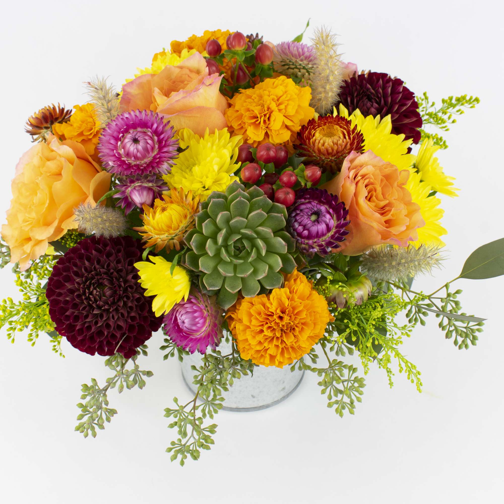 Colorful mixed flower arrangement in a clear vase with a succulent center