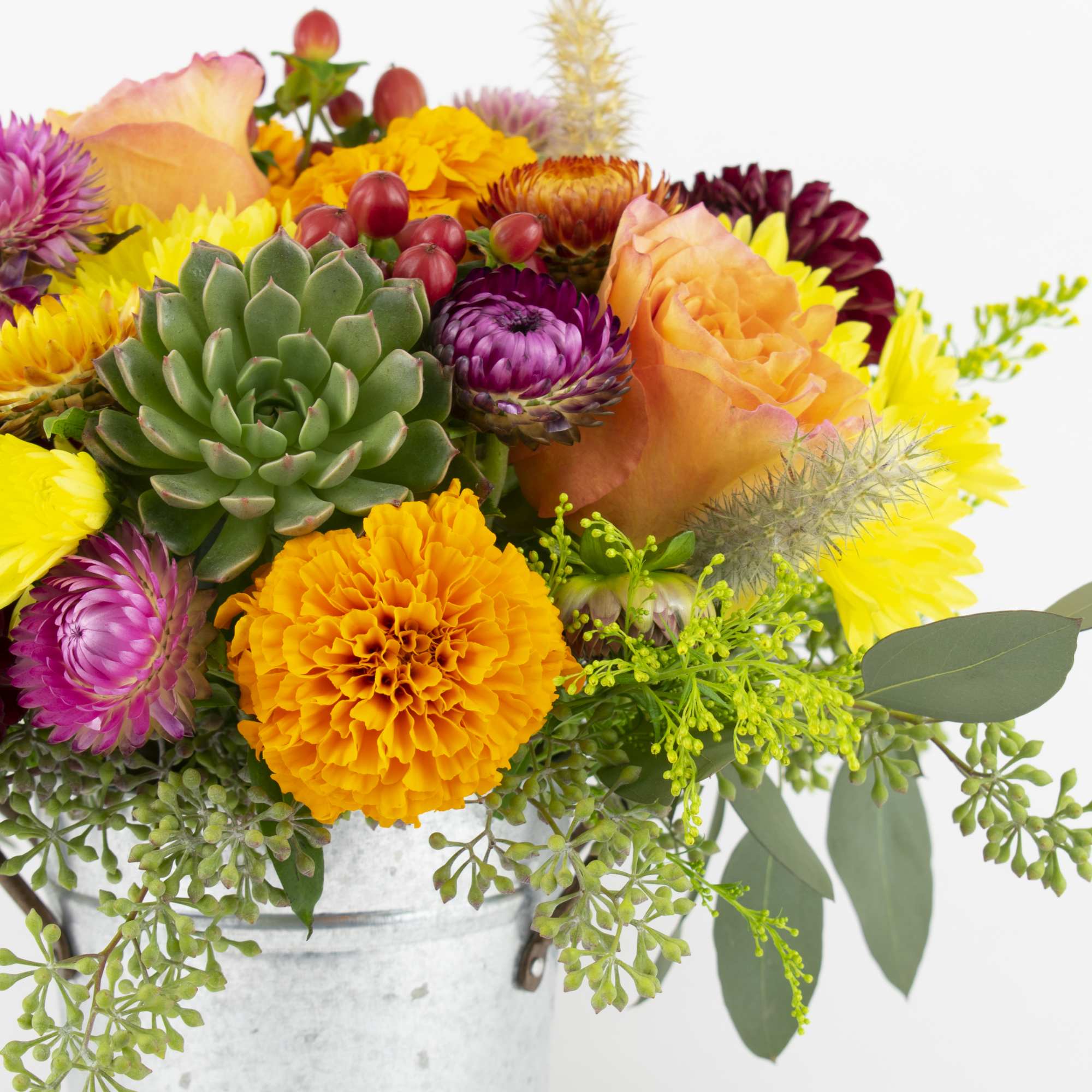 Bright mixed bouquet with roses, chrysanthemums, and a succulent in a metal bucket