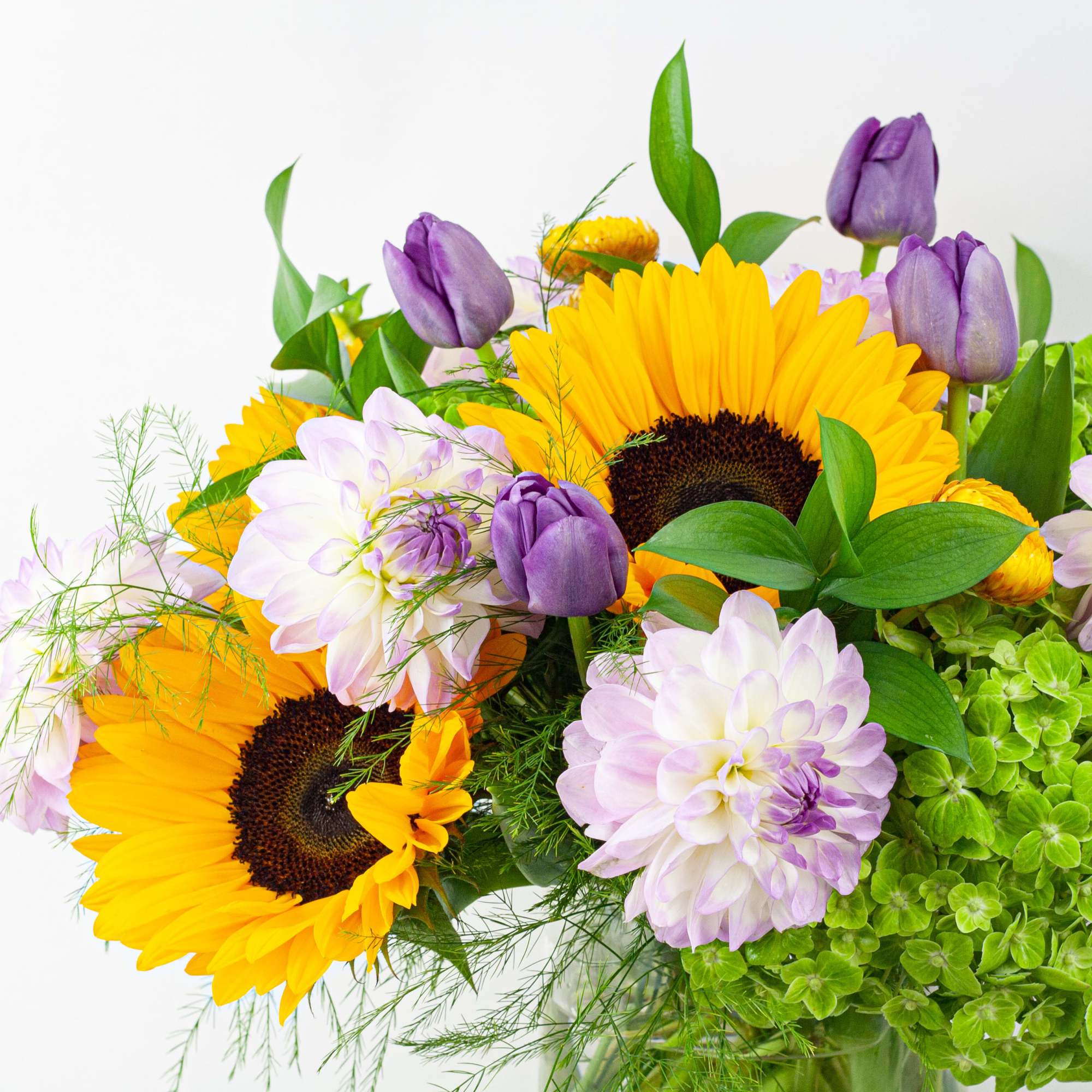 Bouquet of sunflowers, purple tulips, and pale dahlias