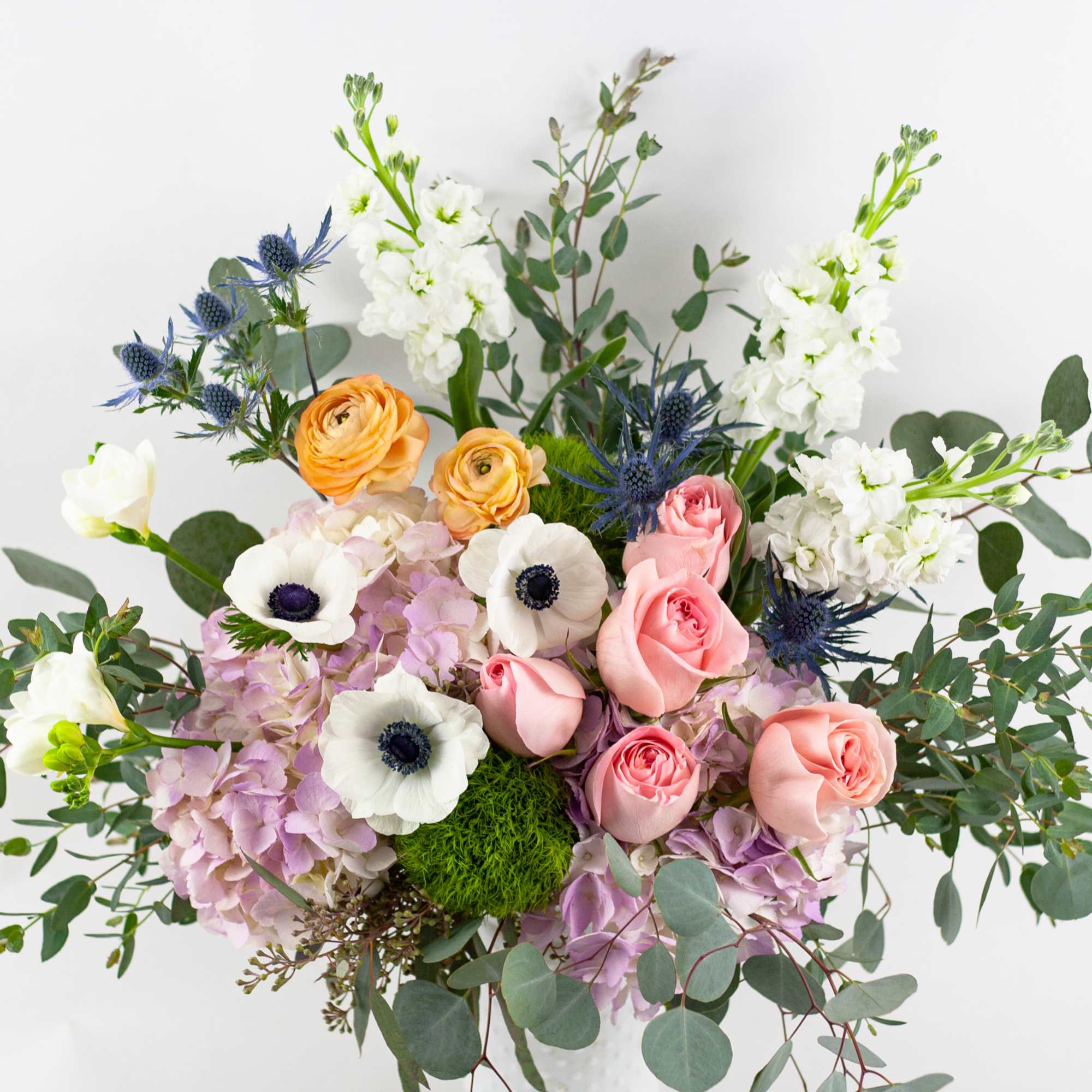 Mixed bouquet of pink and white flowers with blue accents