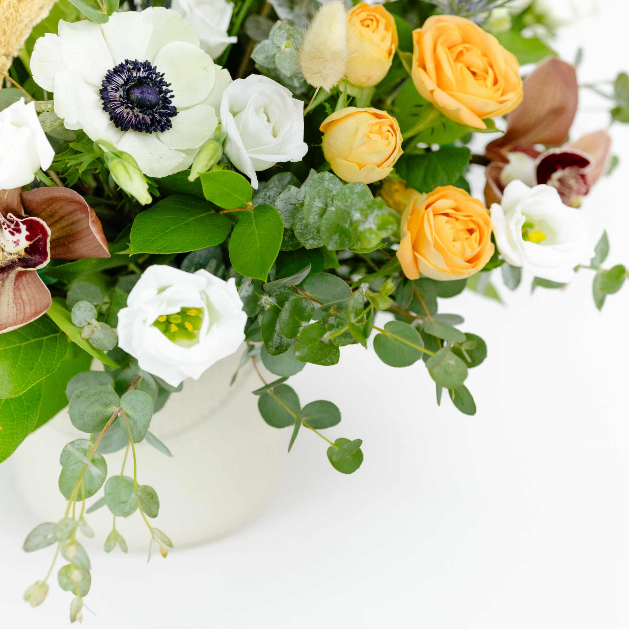 Bouquet of white and orange flowers in a white vase
