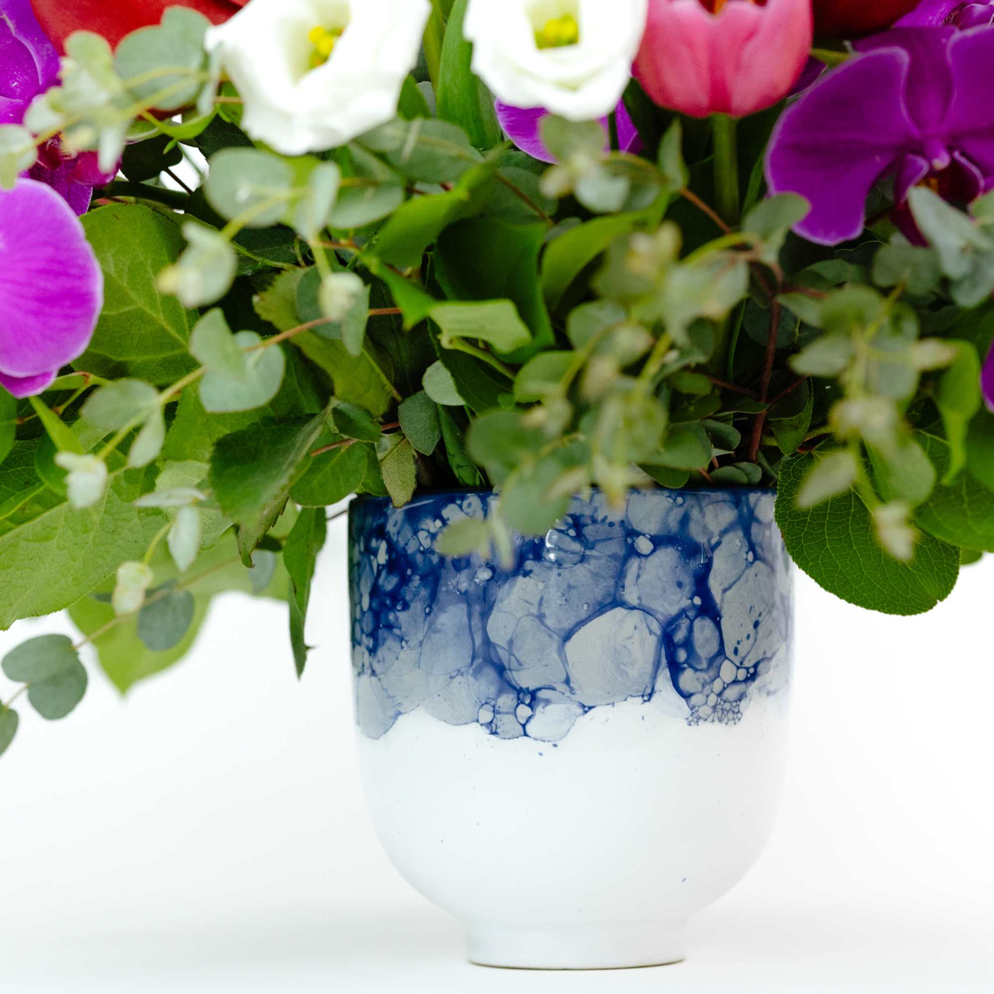 Purple and white orchids in a blue-and-white ceramic vase