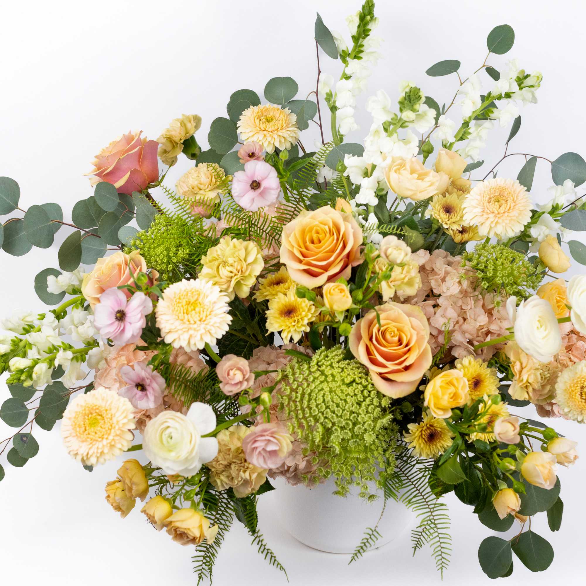 Mixed pastel bouquet in a white vase with eucalyptus