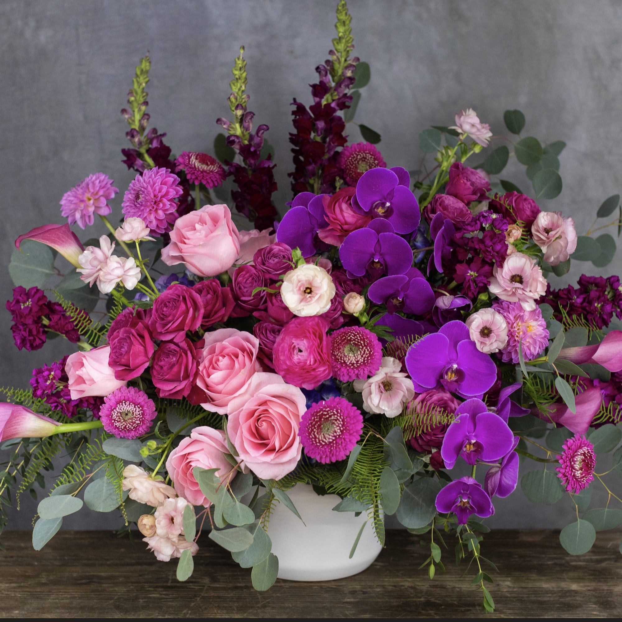 Pink and purple floral arrangement in a white vase