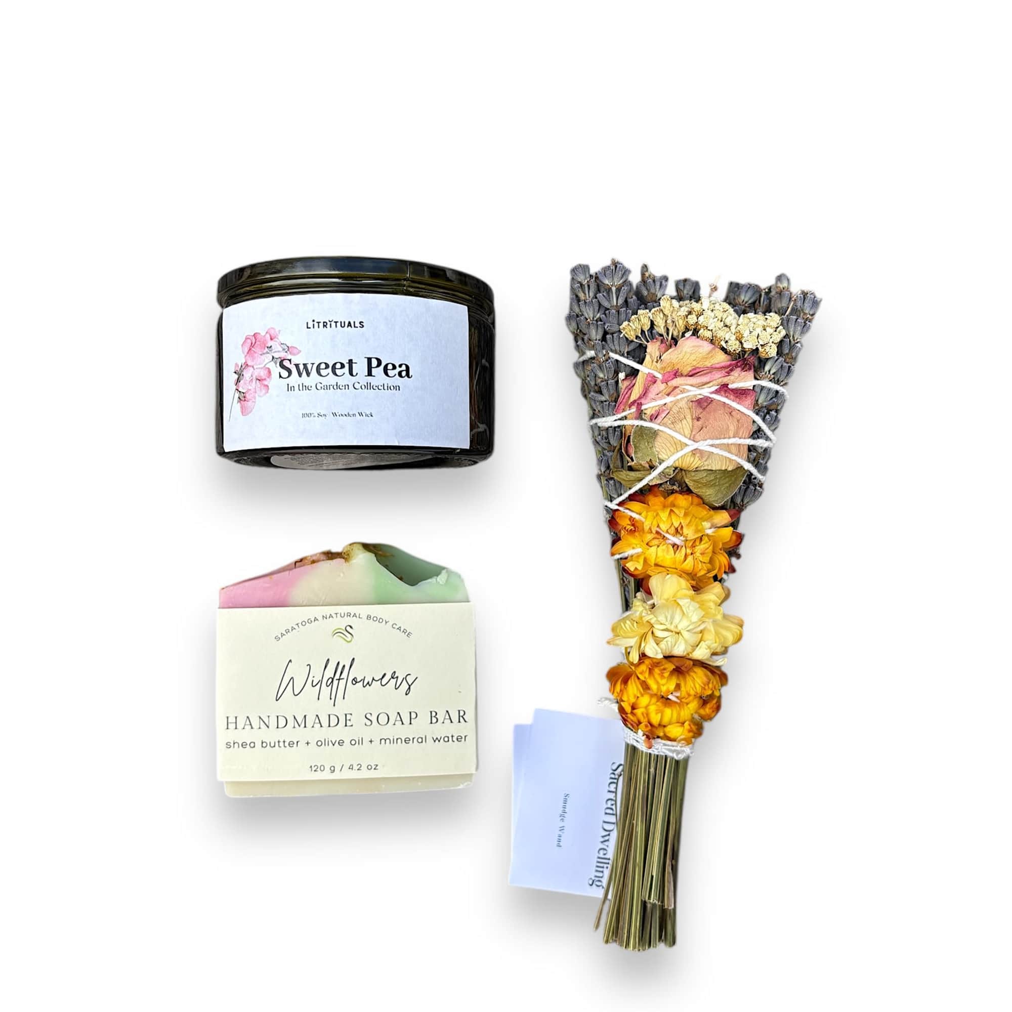 Soap bar, candle, and a small dried flower bundle on a white background