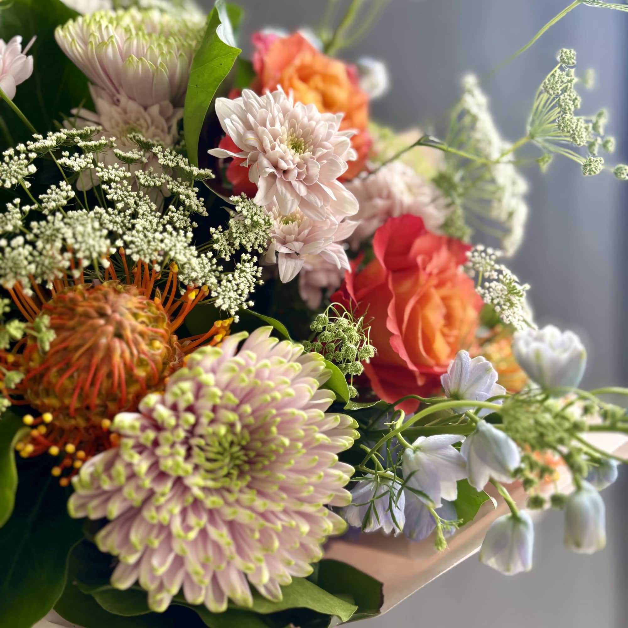 Mixed bouquet with pale pink chrysanthemums and orange roses