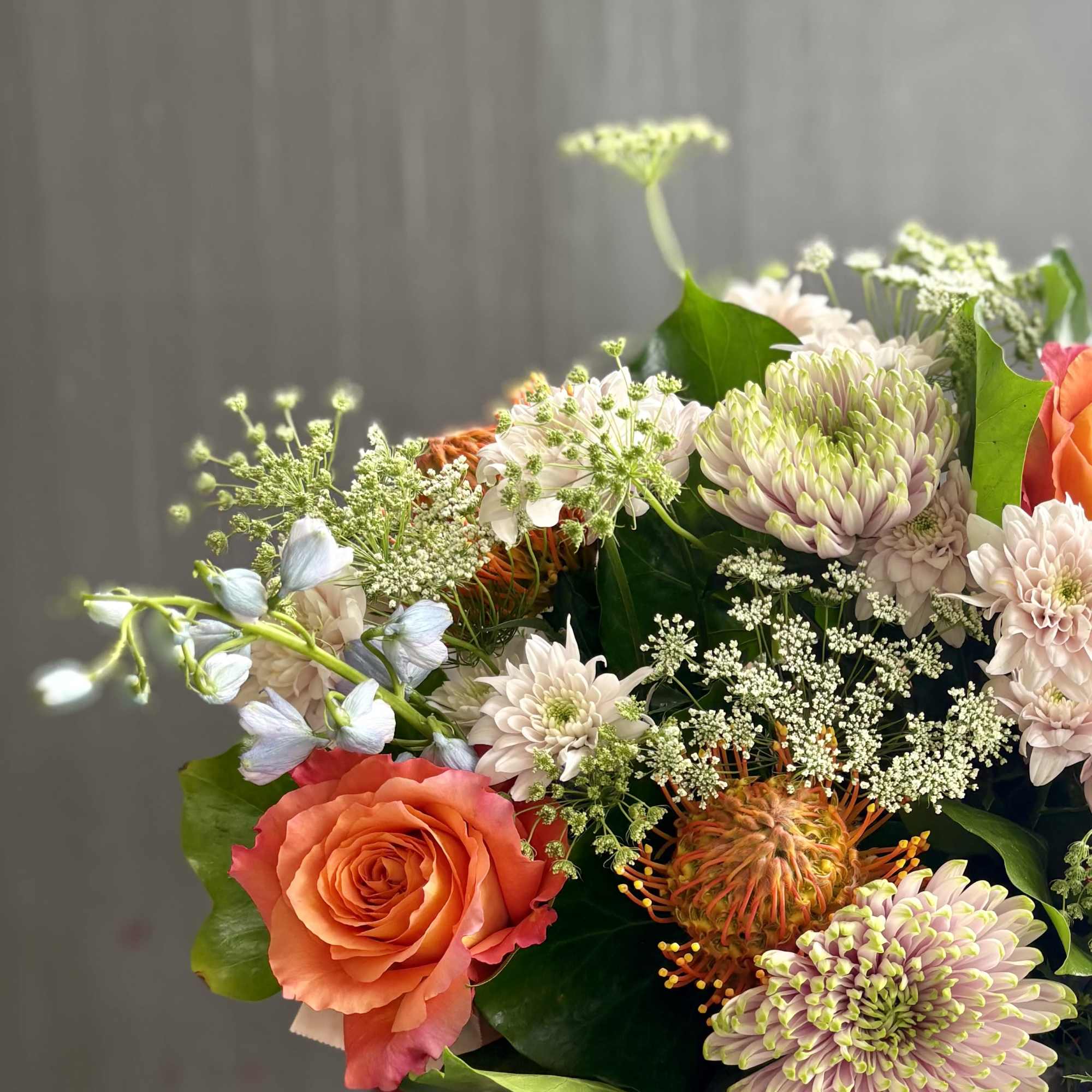 Bouquet of orange roses and pale chrysanthemums with white filler flowers