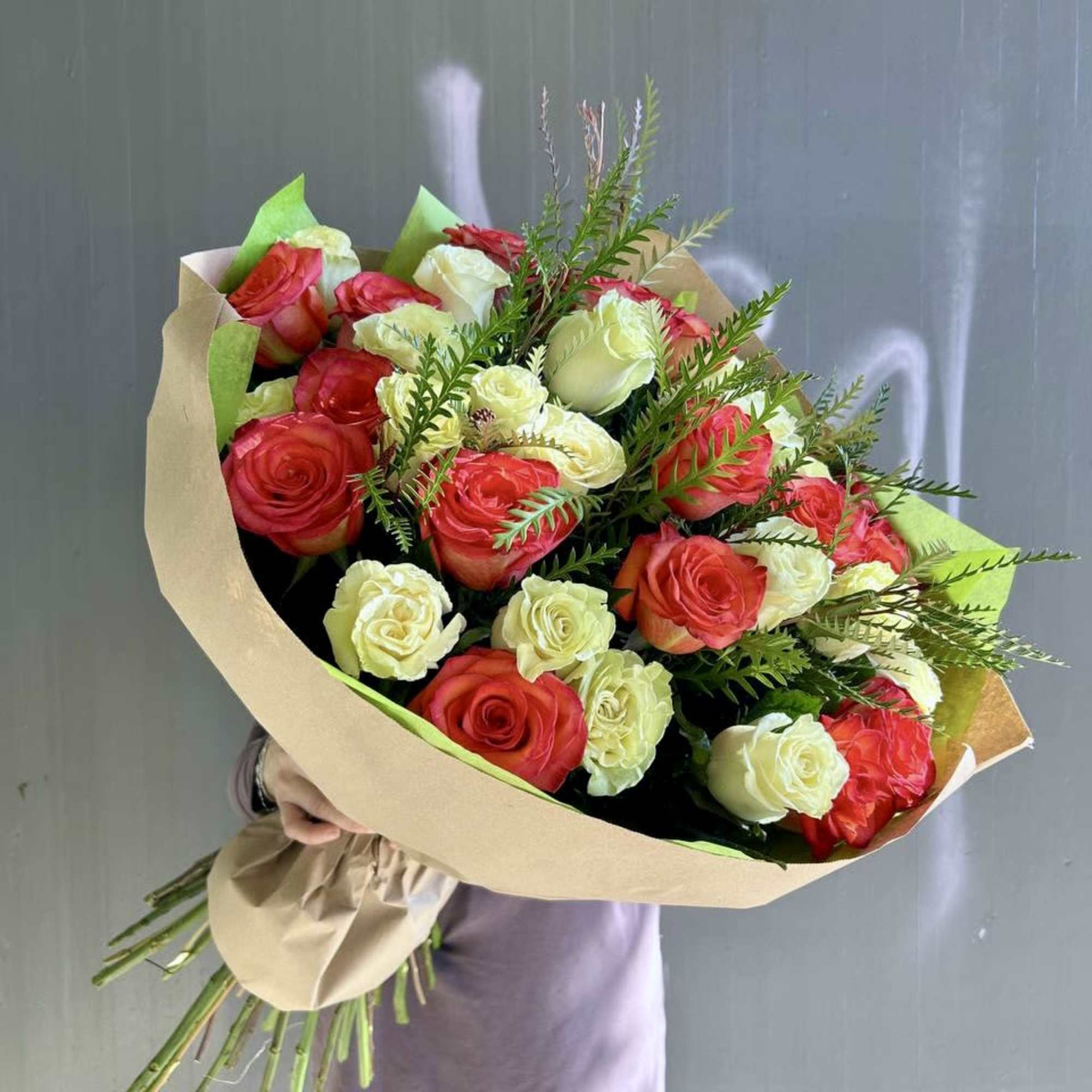 Bouquet of red and white roses wrapped in kraft paper