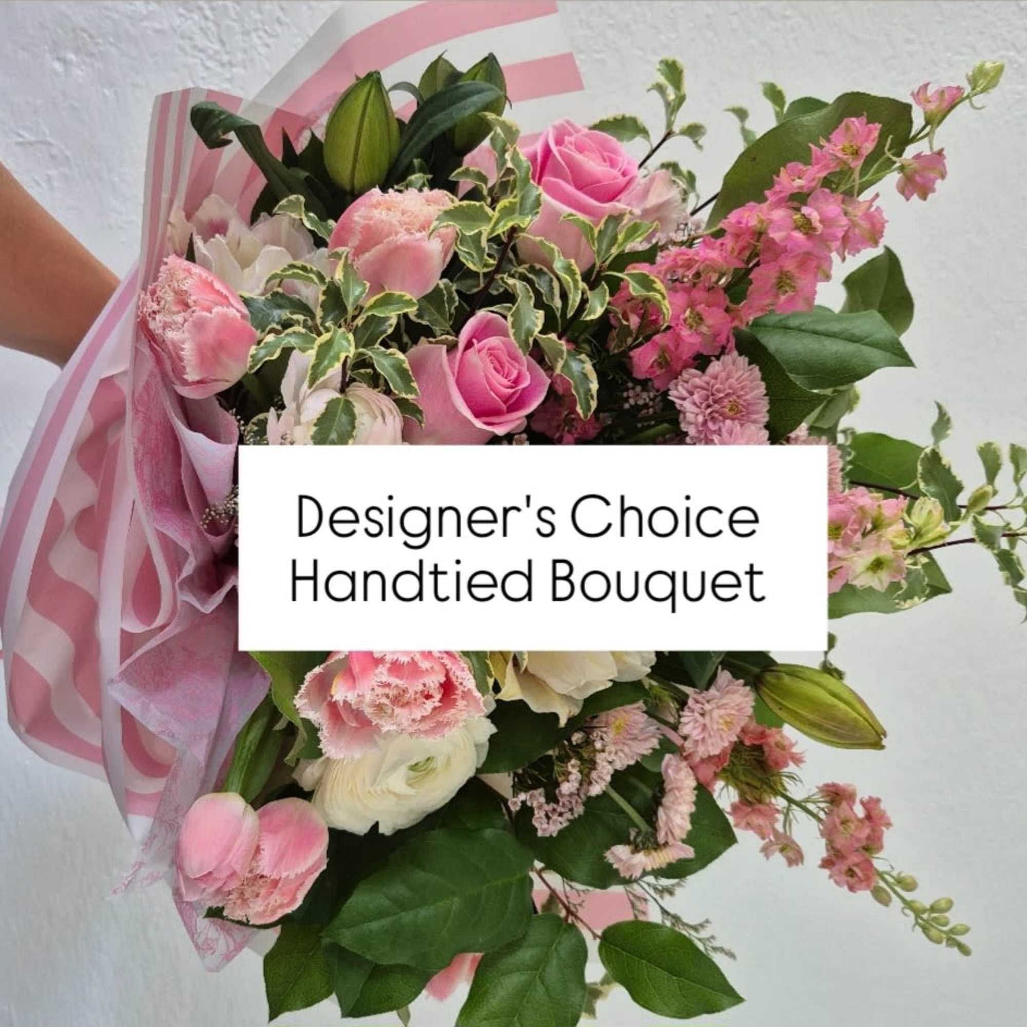 Handtied bouquet of pink and white flowers wrapped in pink paper