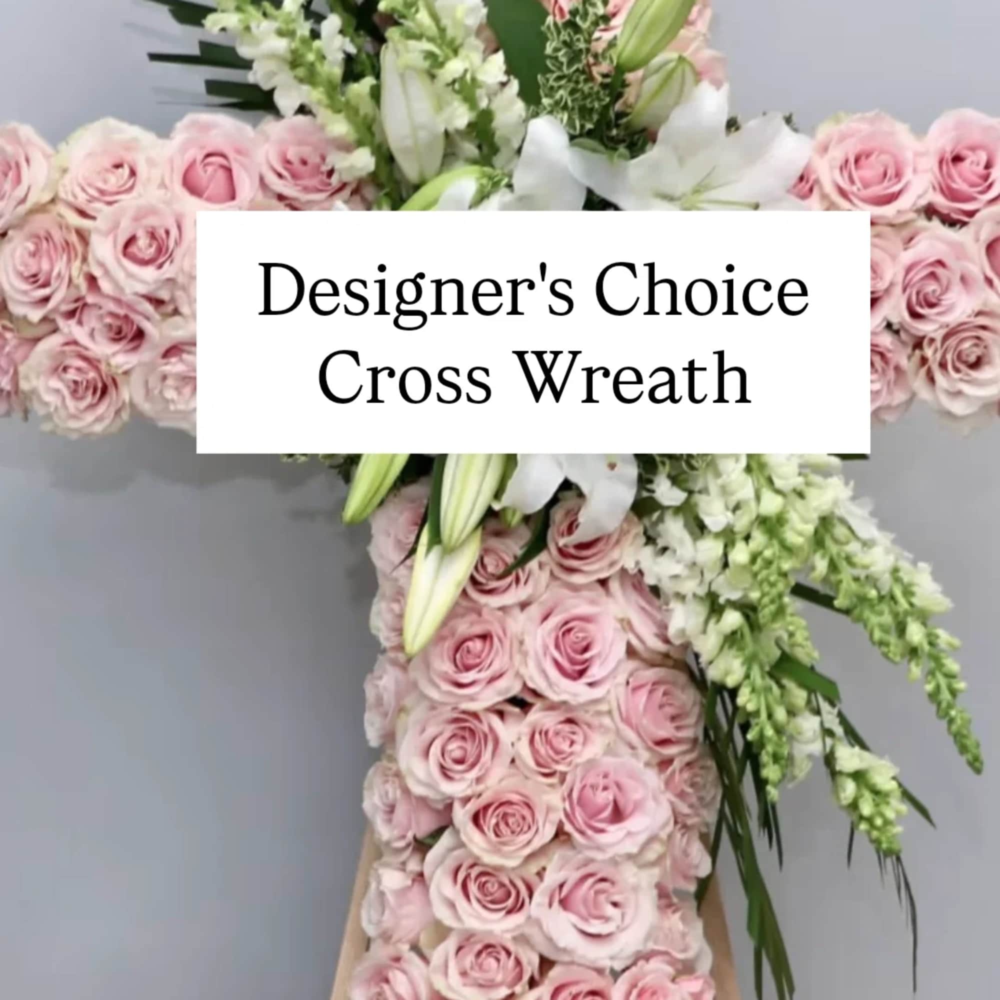 Pink rose cross wreath with white lilies and greenery on an easel