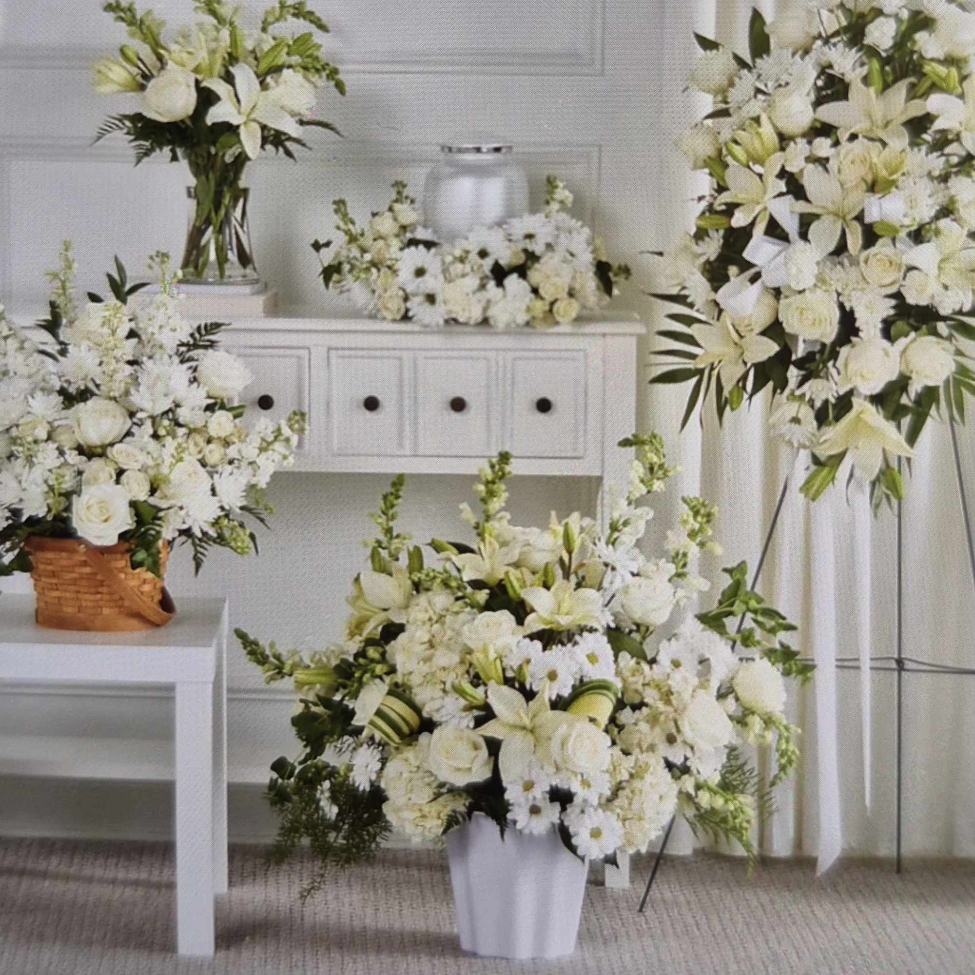 White floral arrangements in vases and a standing spray